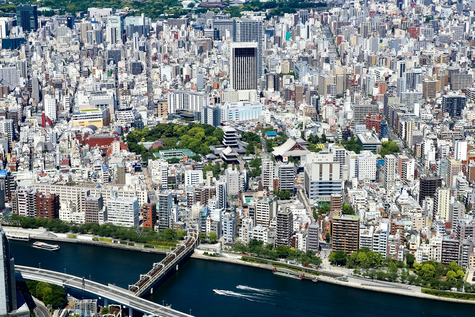 Cảnh trên cao của Tokyo với các tòa nhà chọc trời và một con sông không gian xanh và nhiều tòa nhà