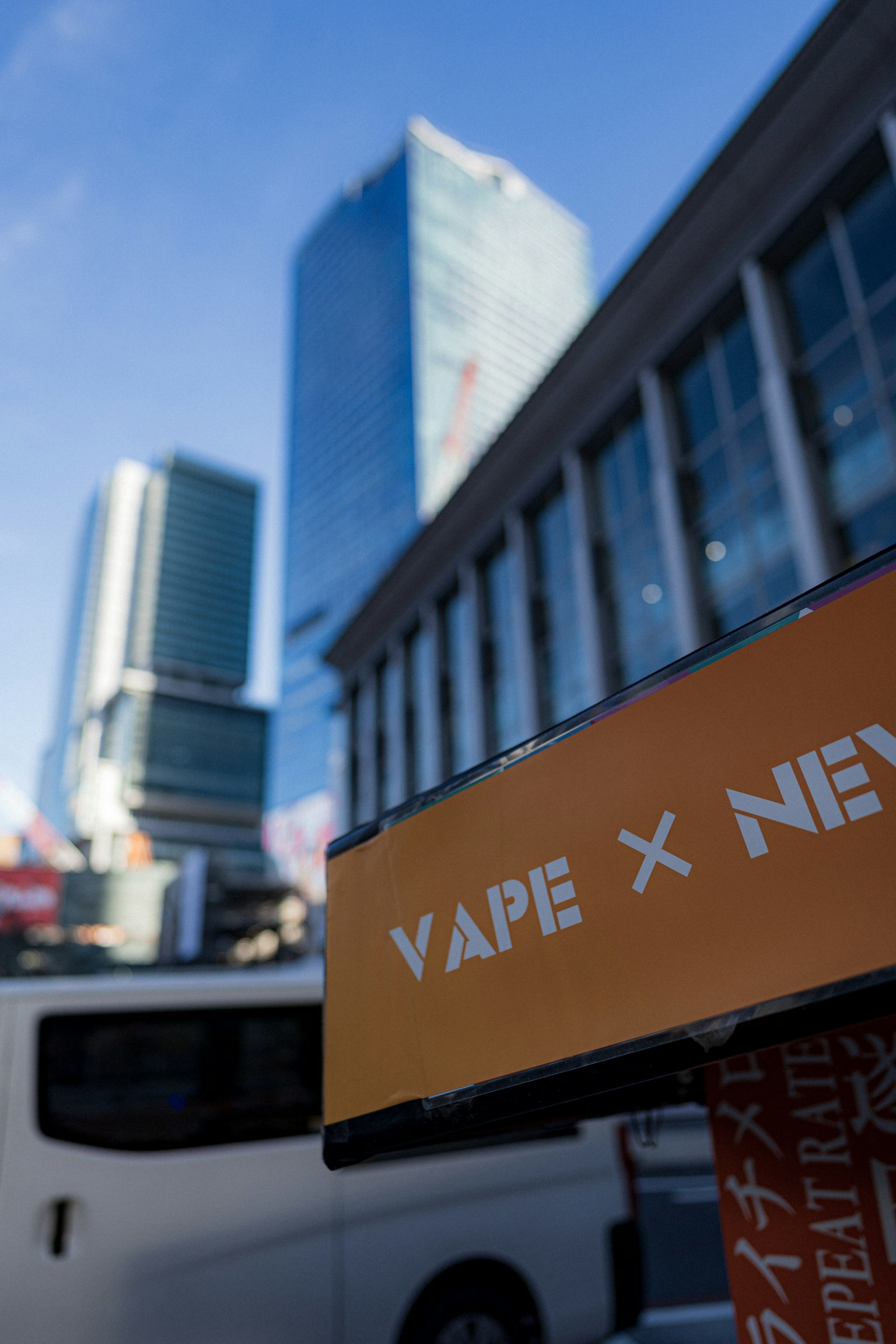 Lanskap perkotaan dengan tanda VAPE X dan gedung modern