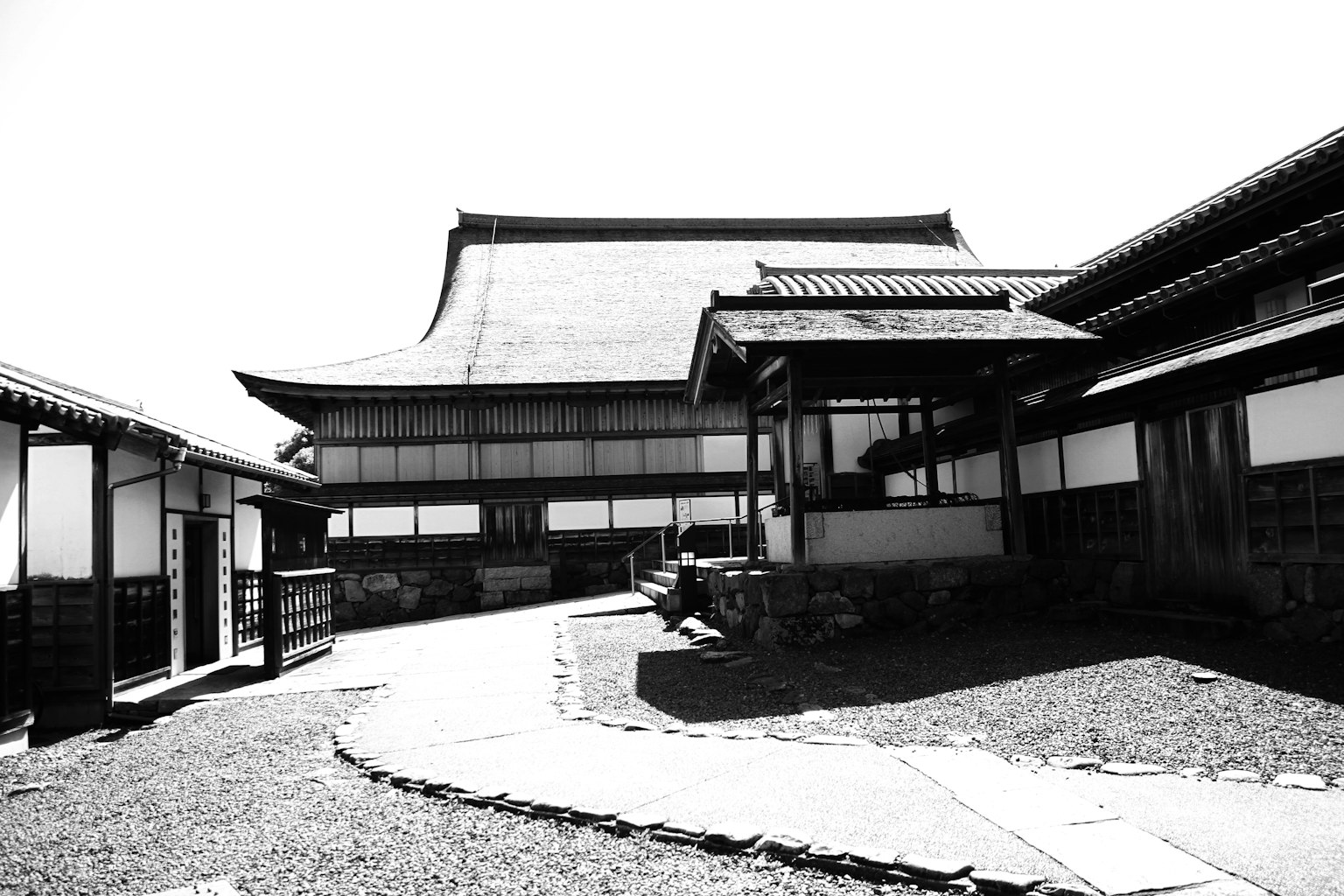 Schwarz-weiße Außenansicht eines japanischen Hauses mit Gartenweg