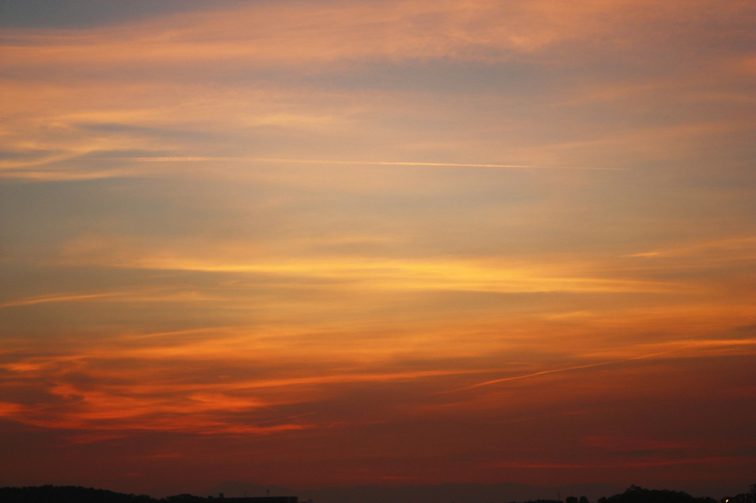 Lebendiger Sonnenuntergang mit orange-gelben Farbverläufen im Himmel