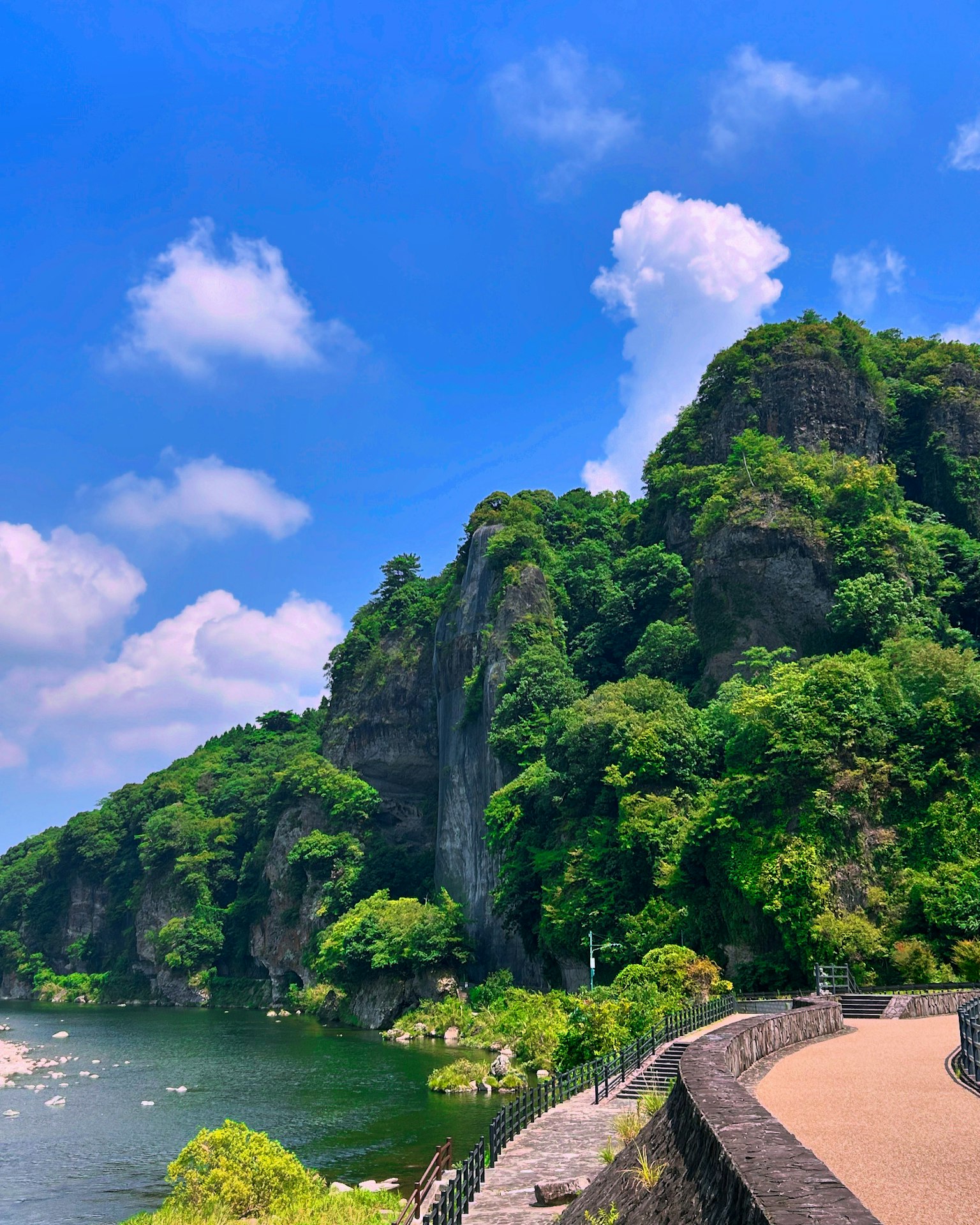 蓝天下河边郁郁葱葱的山脉风景