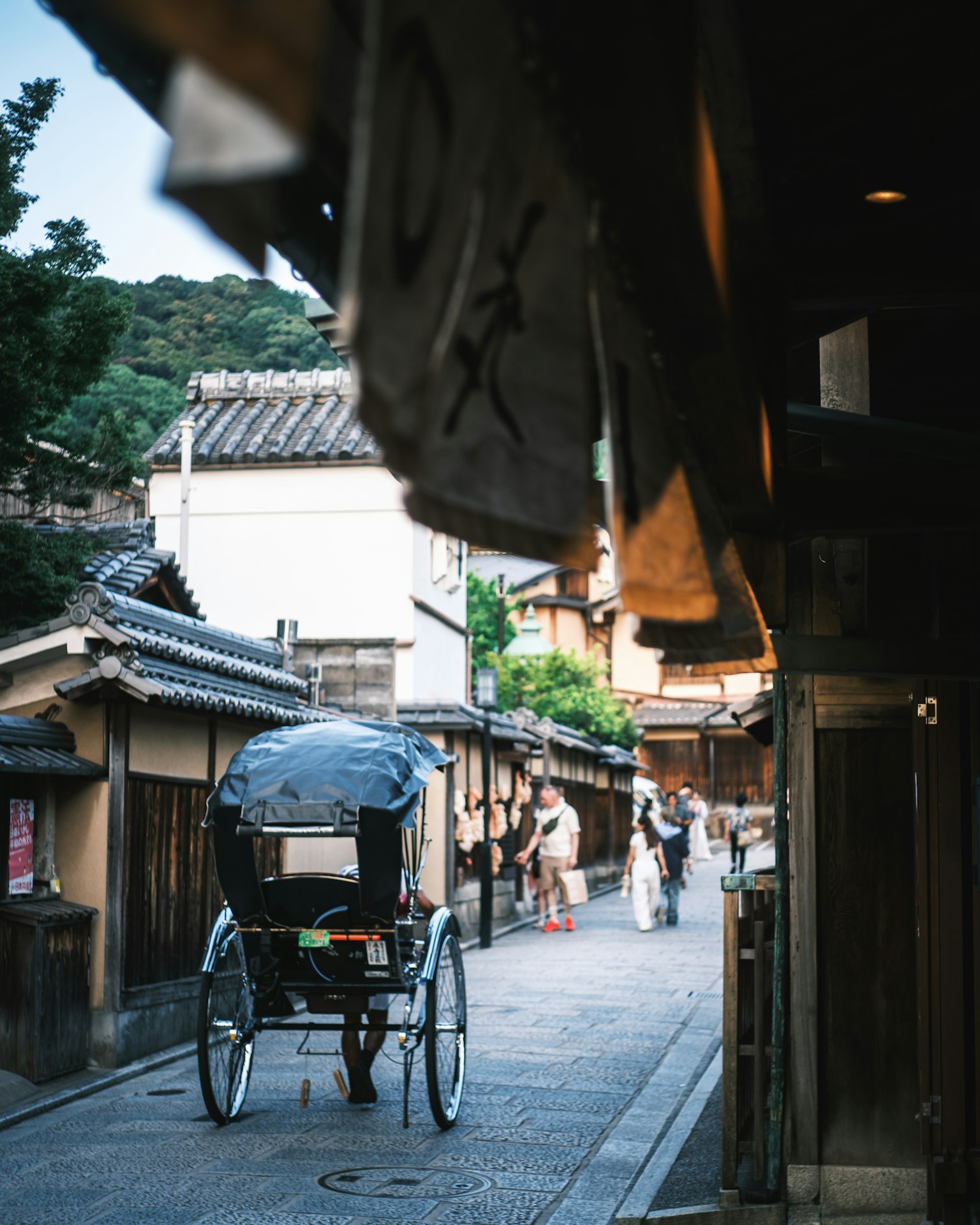 古い街並みを背景にした人力車と散策する人々