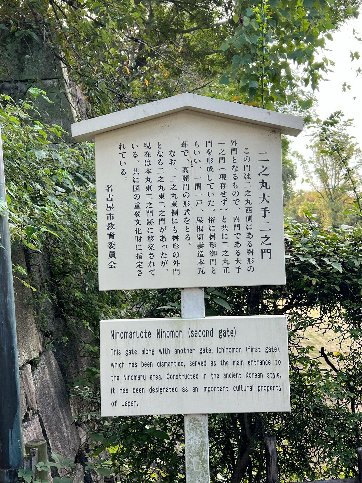 ป้ายที่มีข้อความหลายภาษาอยู่ท่ามกลางพืชพรรณ