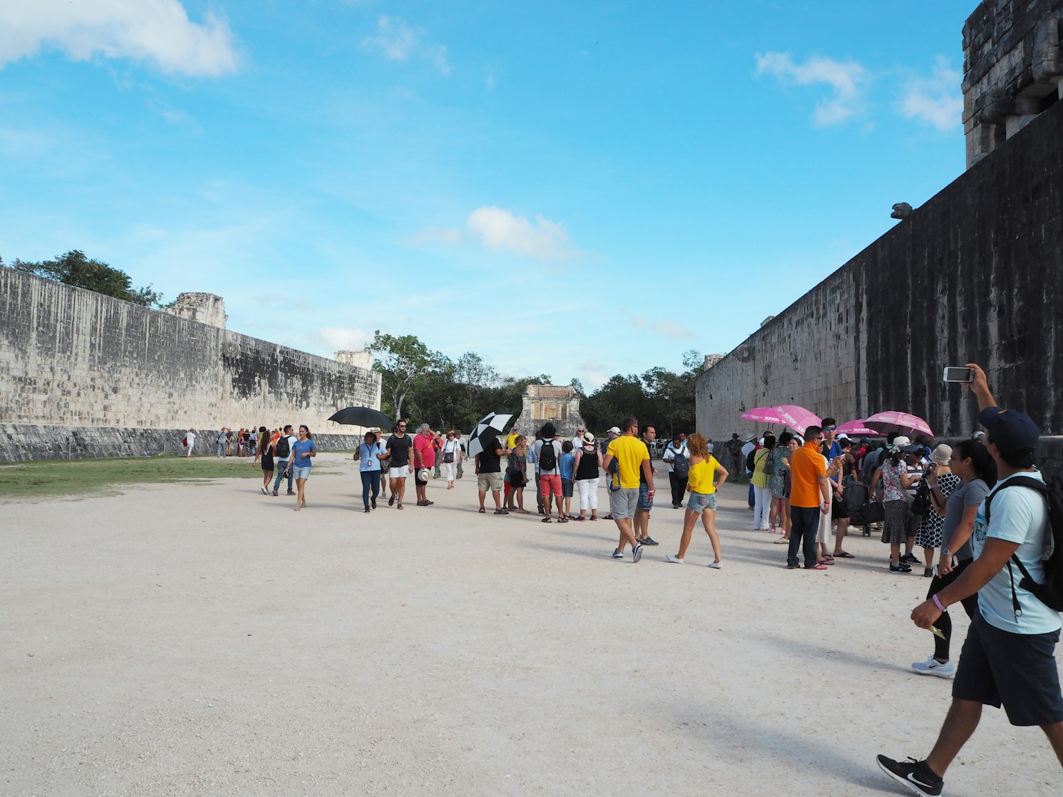 Đám đông du khách tham quan di tích Chichen Itza với ô dưới bầu trời xanh