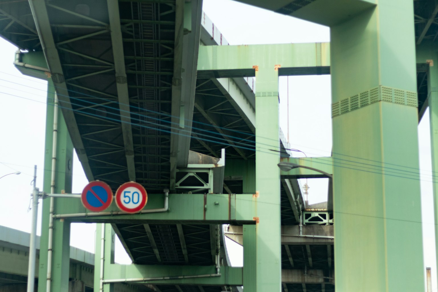 Scena urbana con un viadotto verde e segnali stradali
