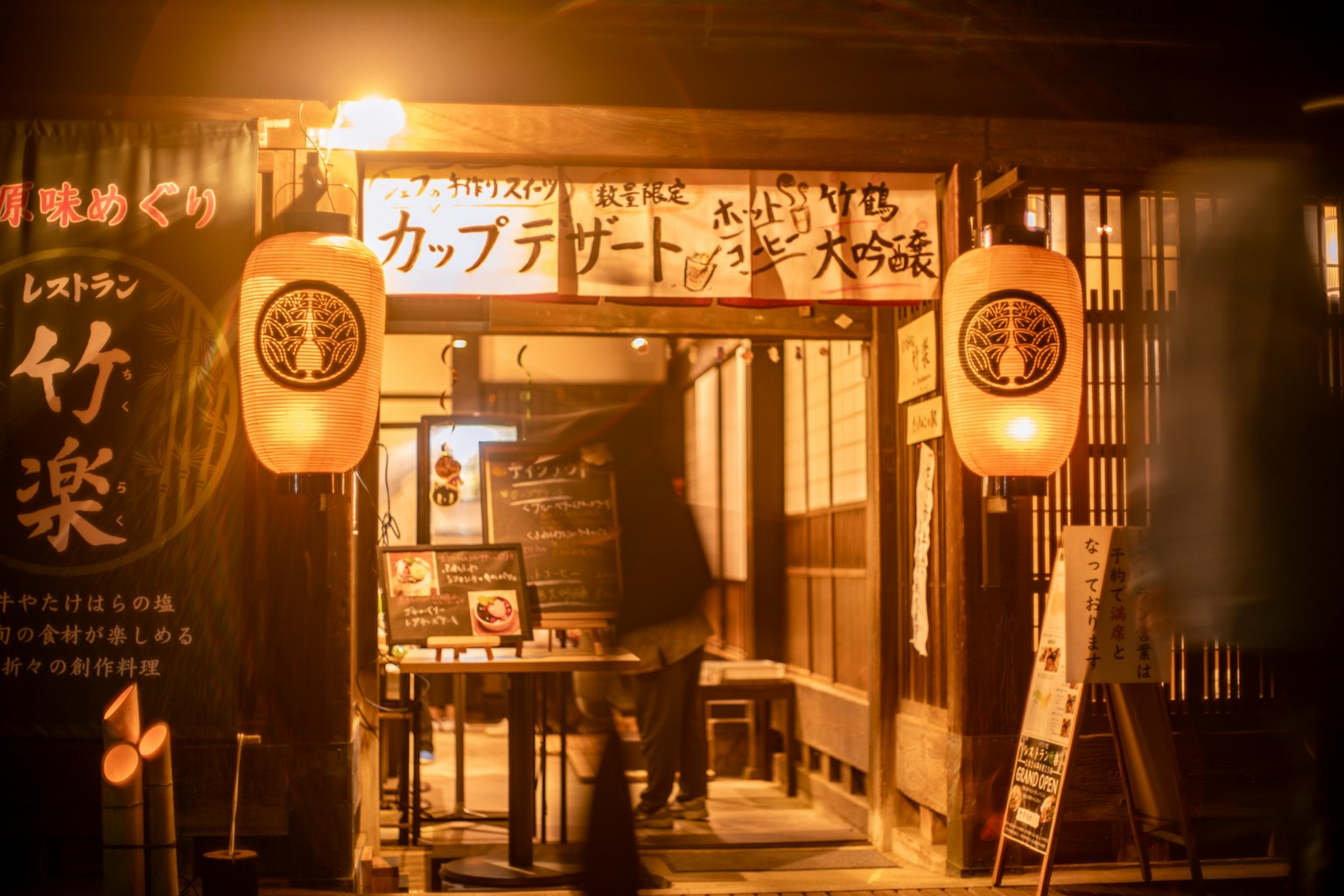 Außenansicht eines japanischen Izakaya bei Nacht mit roten Laternen und Beschilderung