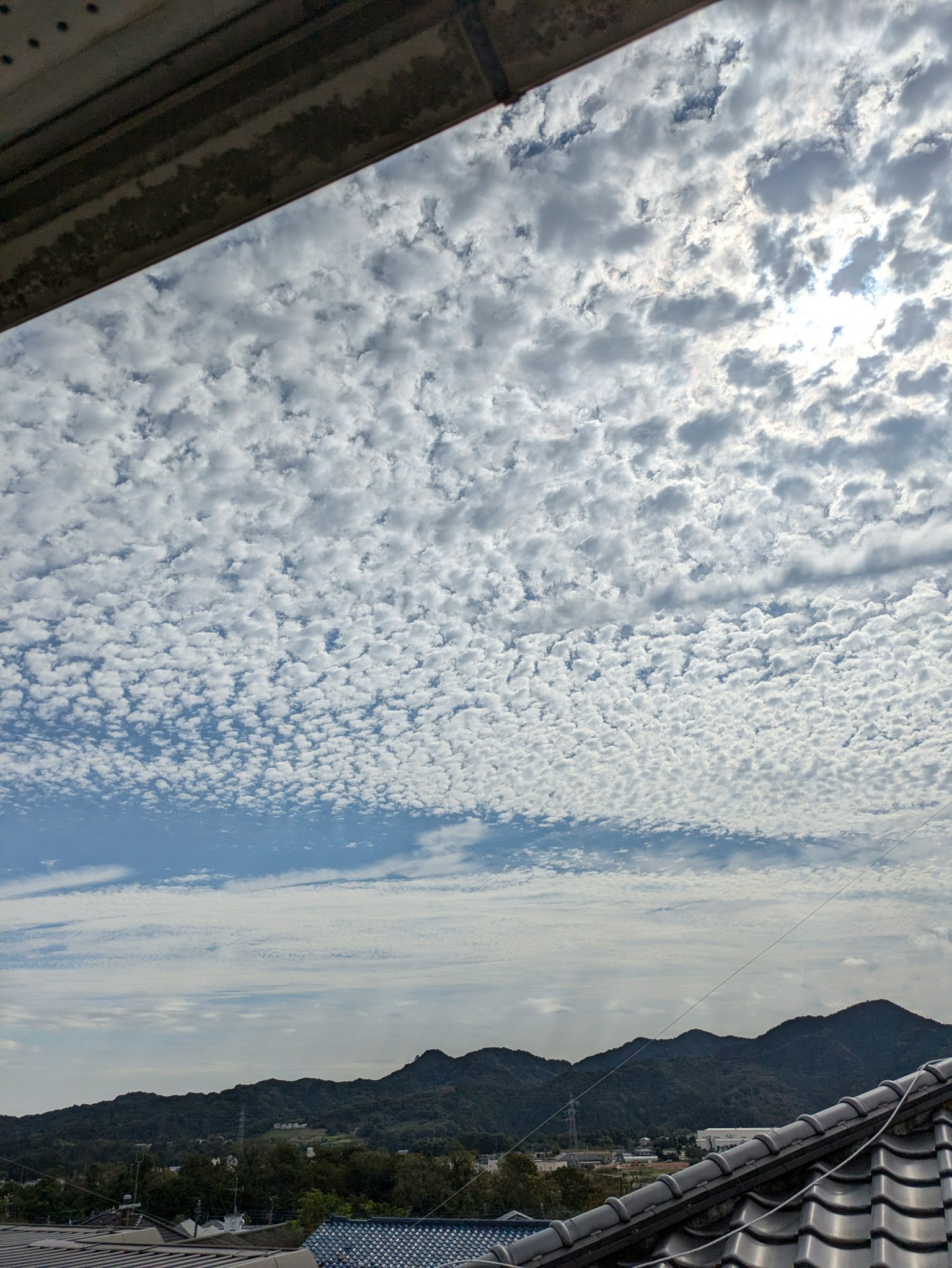Musterwolken in einem blauen Himmel mit Bergen im Hintergrund