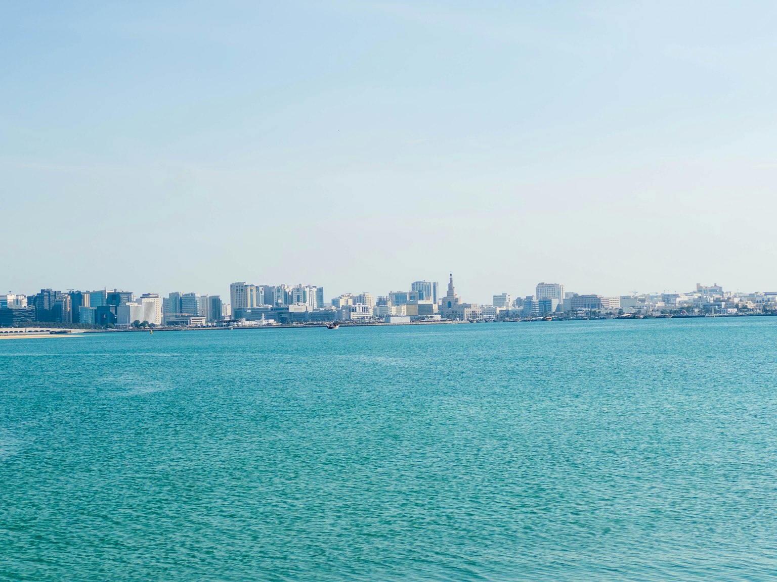 Vista di un mare turchese con uno skyline urbano