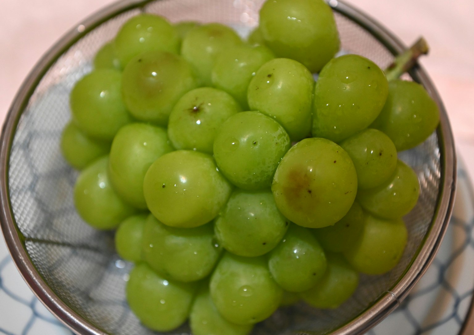 Fresh green grapes in a mesh bowl