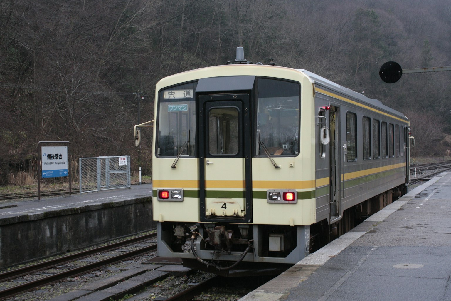 Train stopped at a station on a cold foggy day