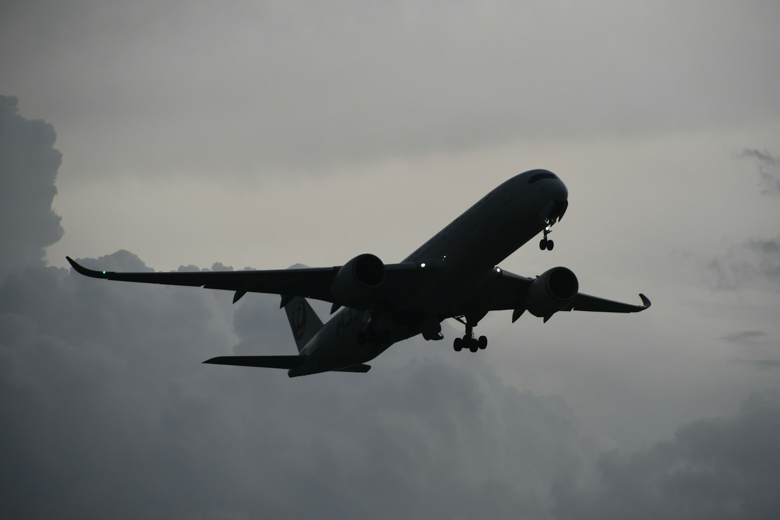 Silhouette of an airplane flying through clouds