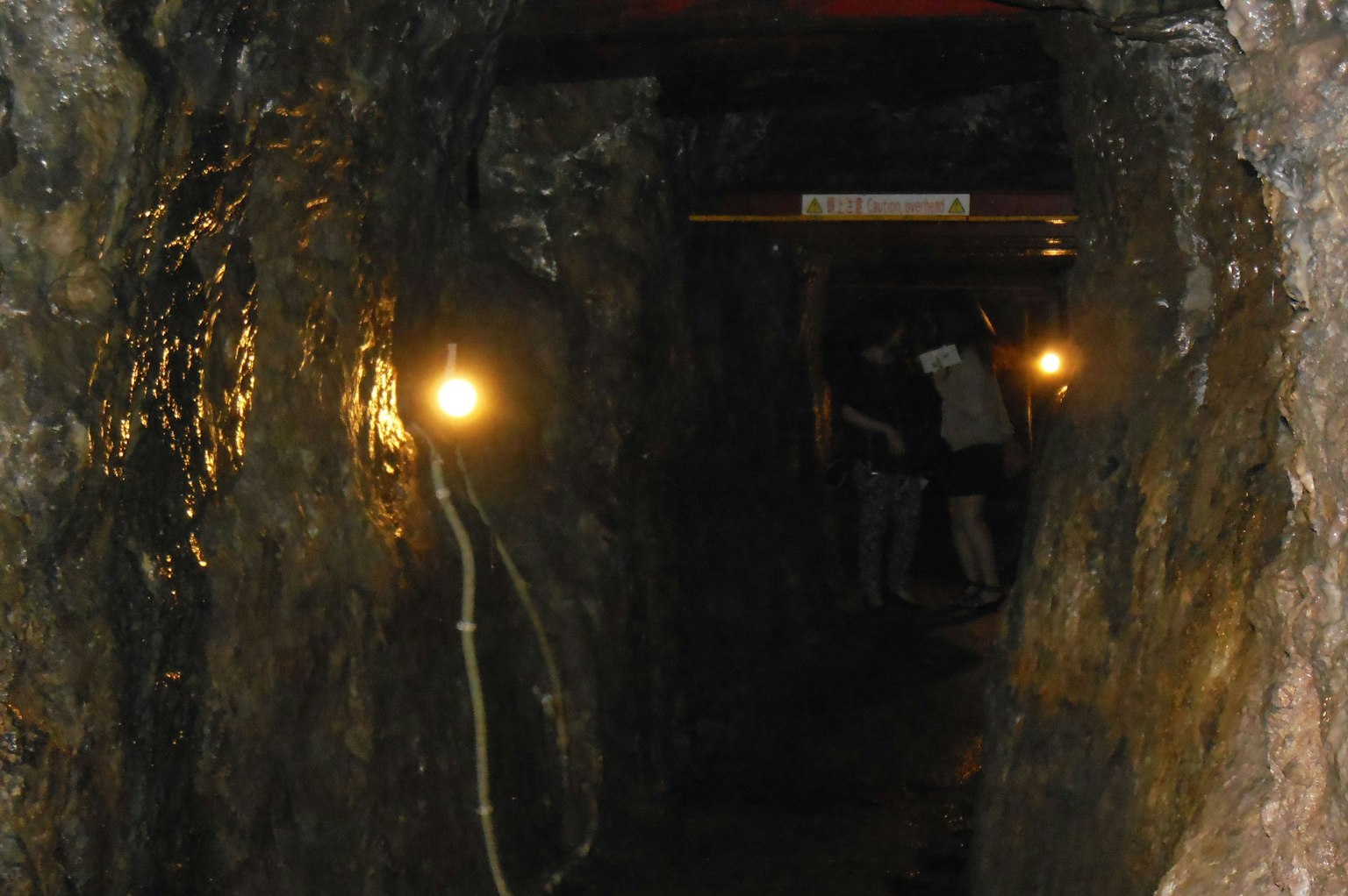 Interior of a dark tunnel with light sources and rocky walls