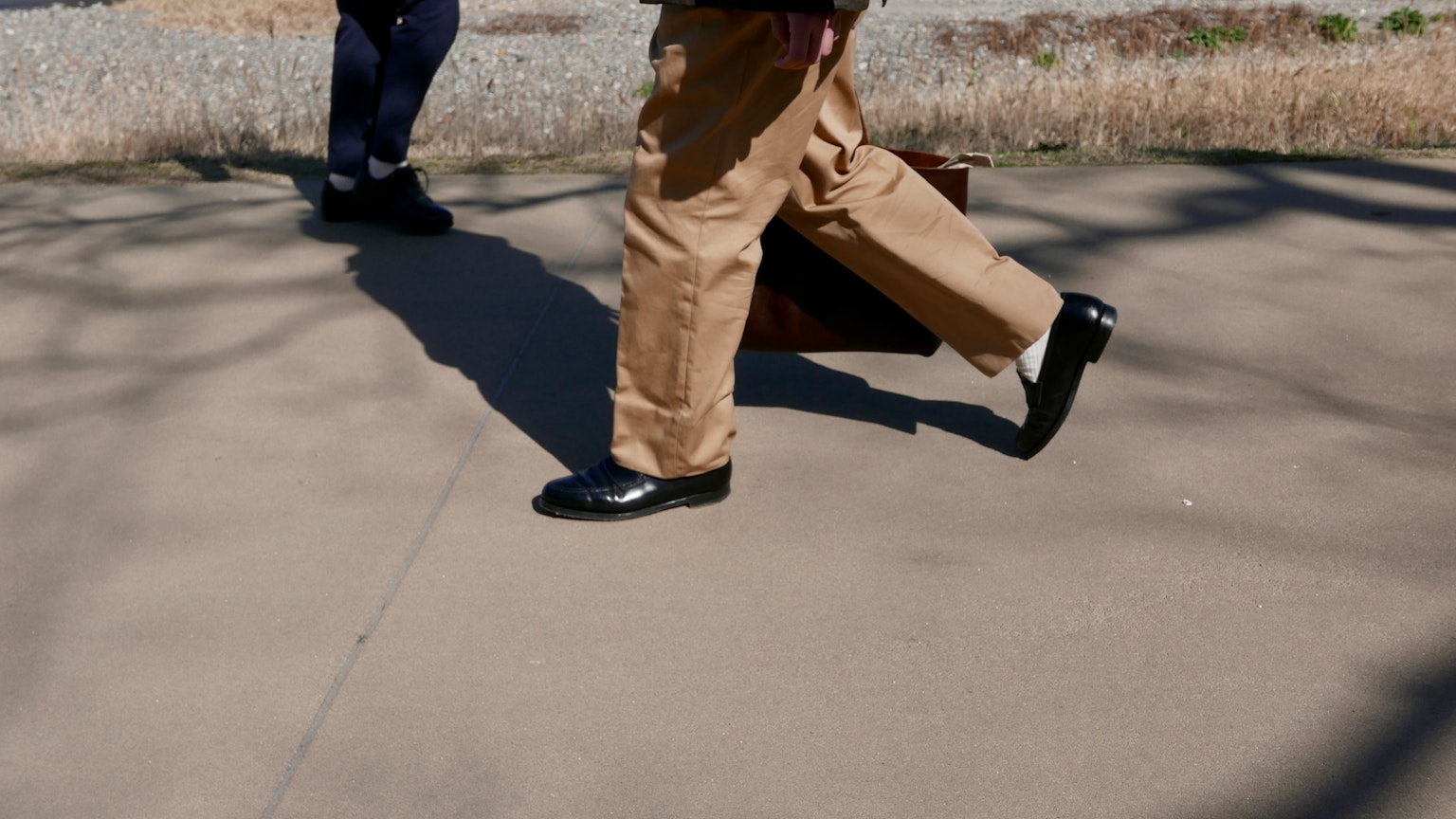 Homme d'affaires marchant en chaussures habillées et pantalons beiges