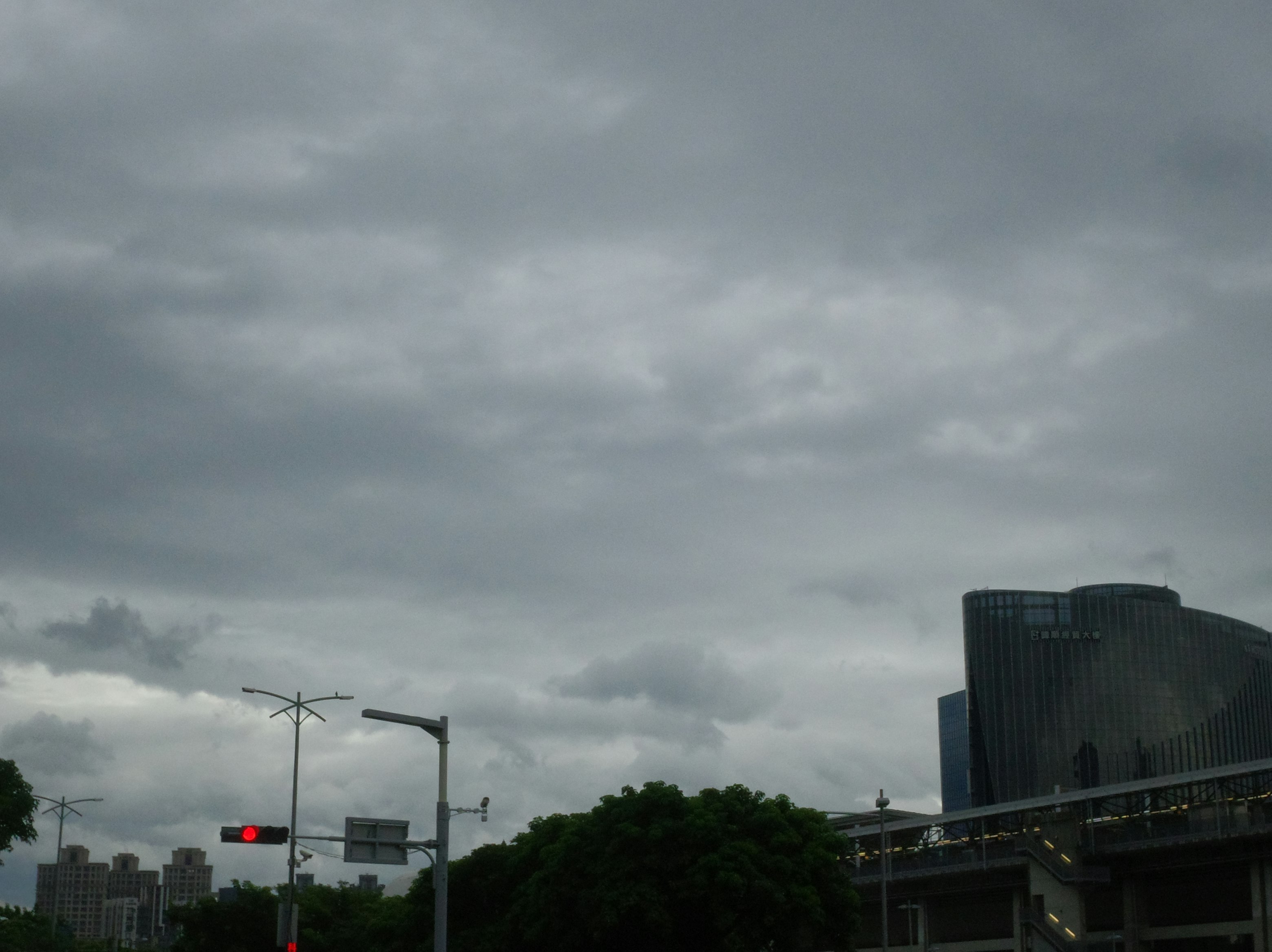 雲の多い空の下の高架道路とビル群