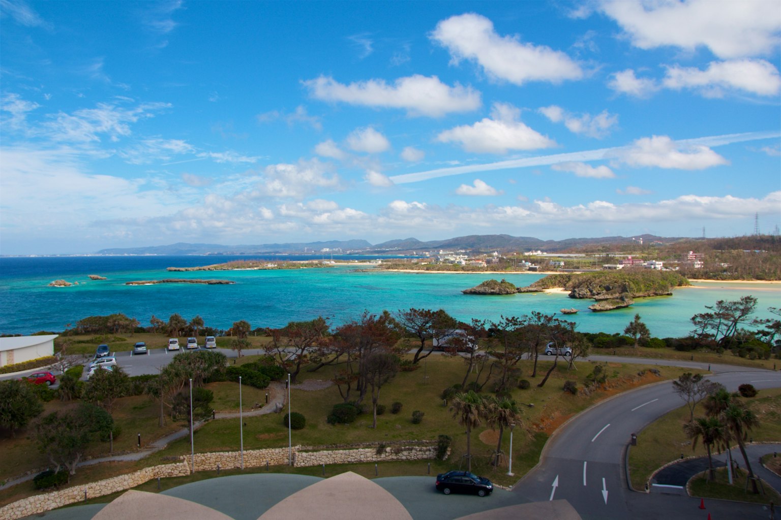 碧绿色海洋与白色云朵的风景 沿海岸线的郁郁葱葱的植被