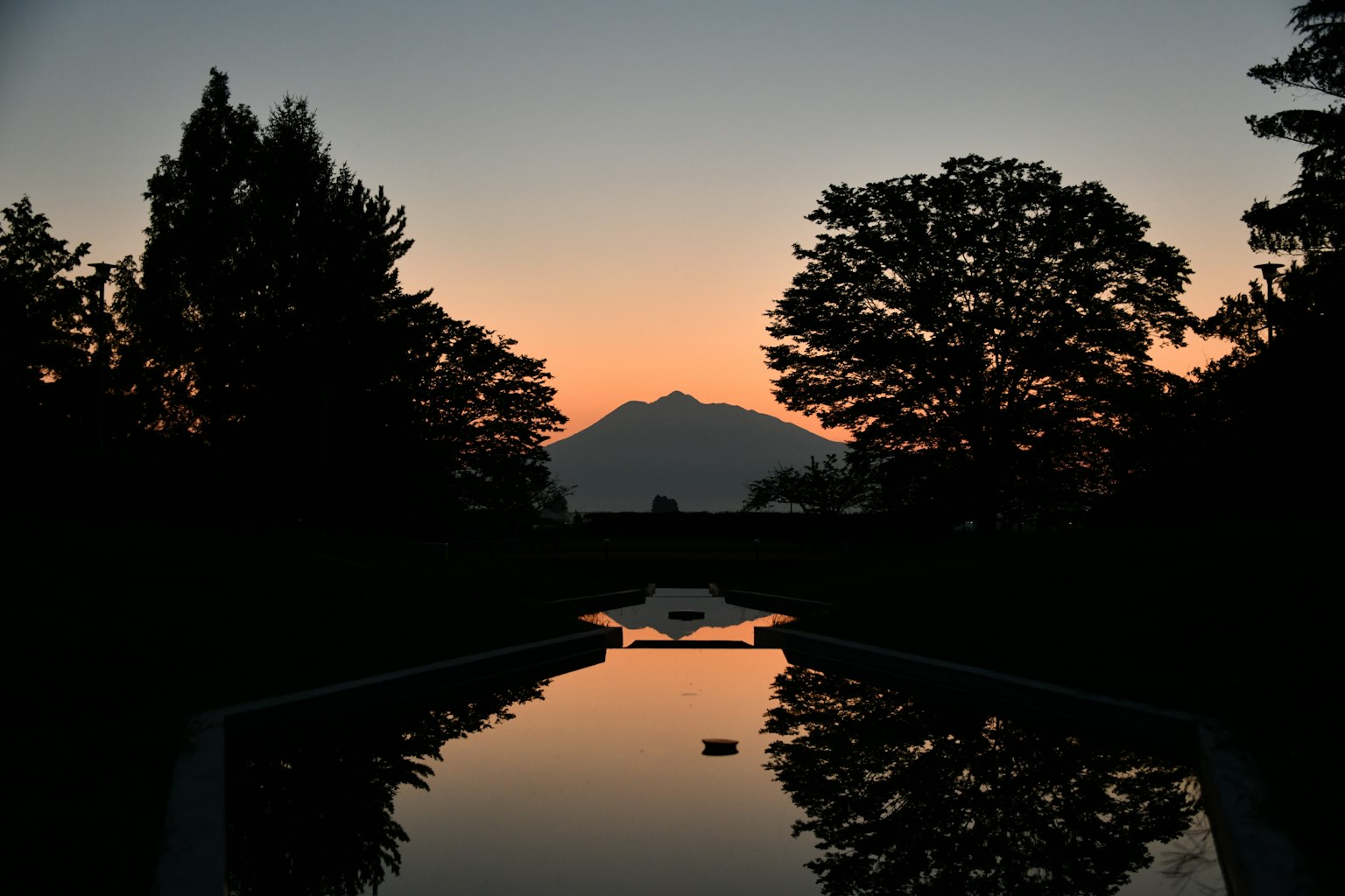 Vista panoramica di una montagna al tramonto riflessa nell'acqua