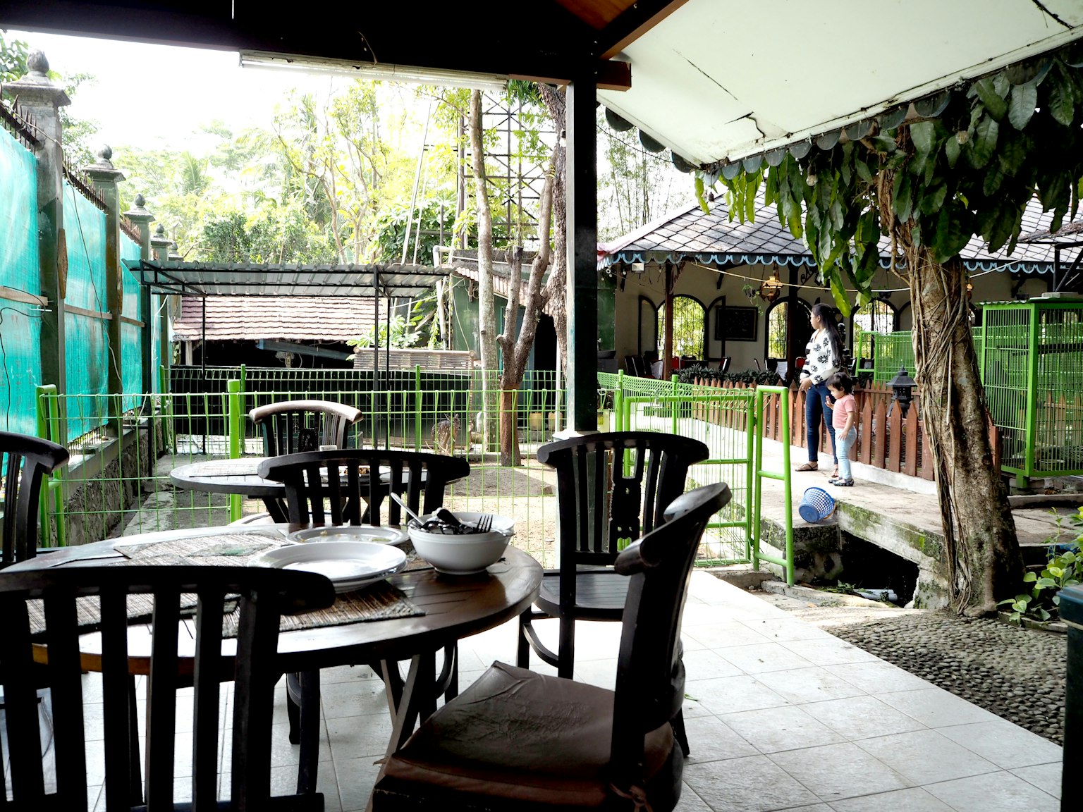 Blick auf ein ruhiges Gartenrestaurant mit Tischen und Stühlen