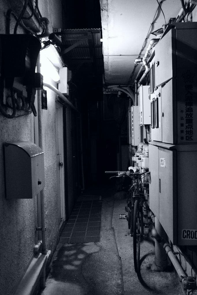passage sombre dans une ruelle avec des vélos le long des murs