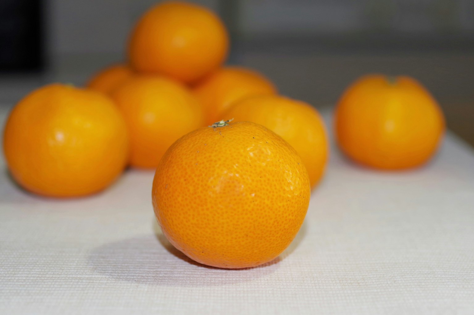 Sekelompok jeruk mandarin oranye cerah disusun di atas meja