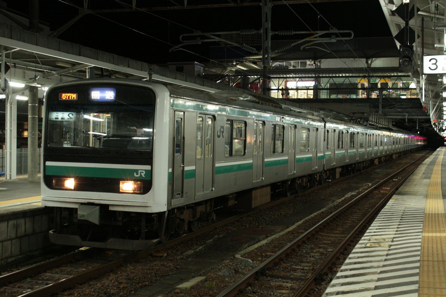 Tren verde y plateado detenido en la estación de noche