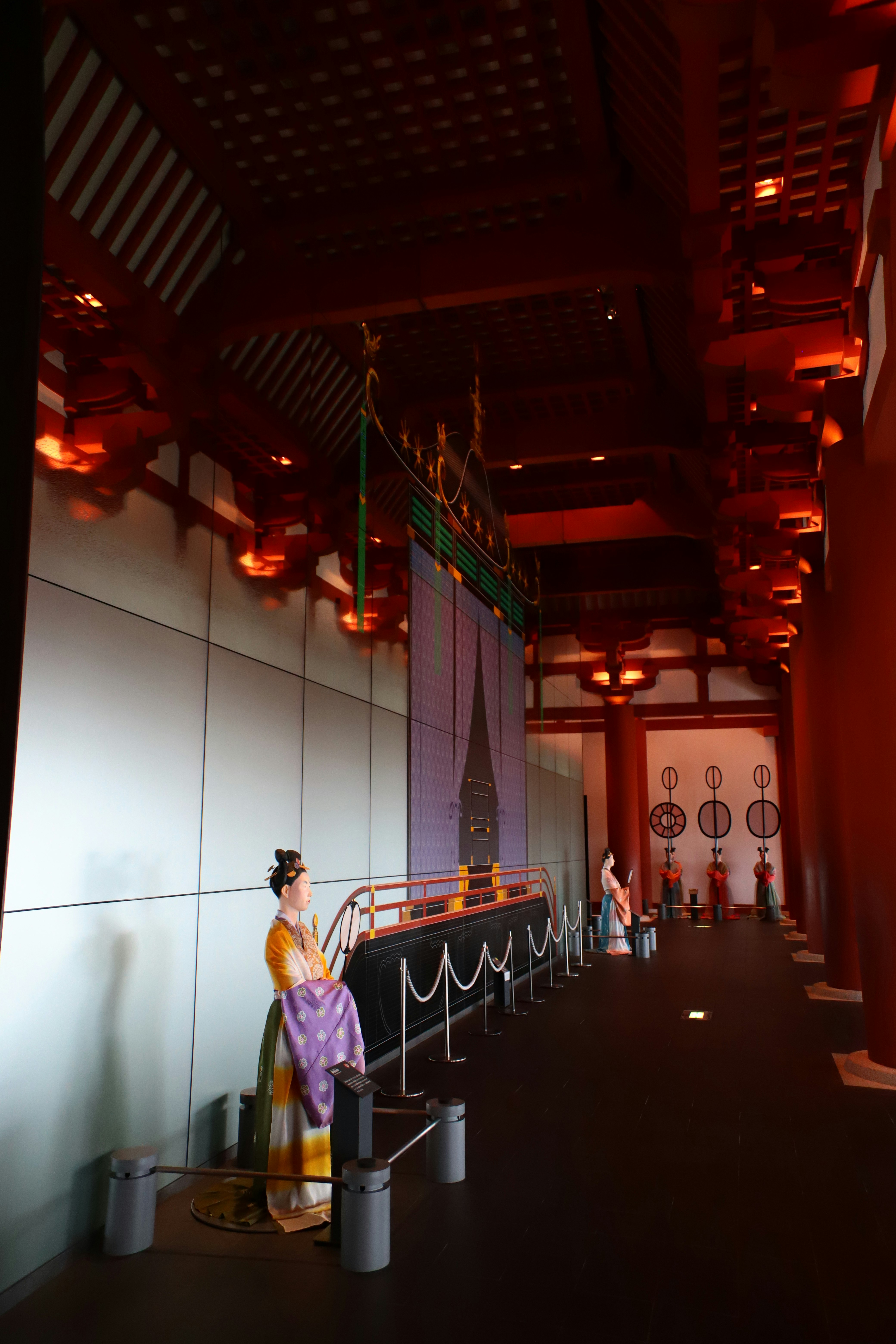 Interior of a building with red decorations featuring a woman in traditional attire