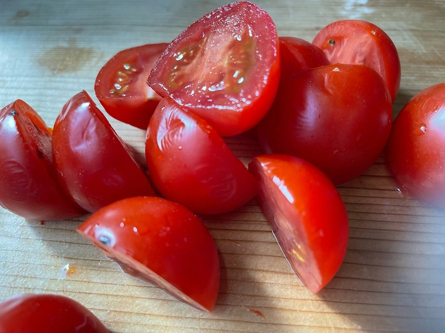 Pomodori rossi tagliati disposti su un tavolo di legno