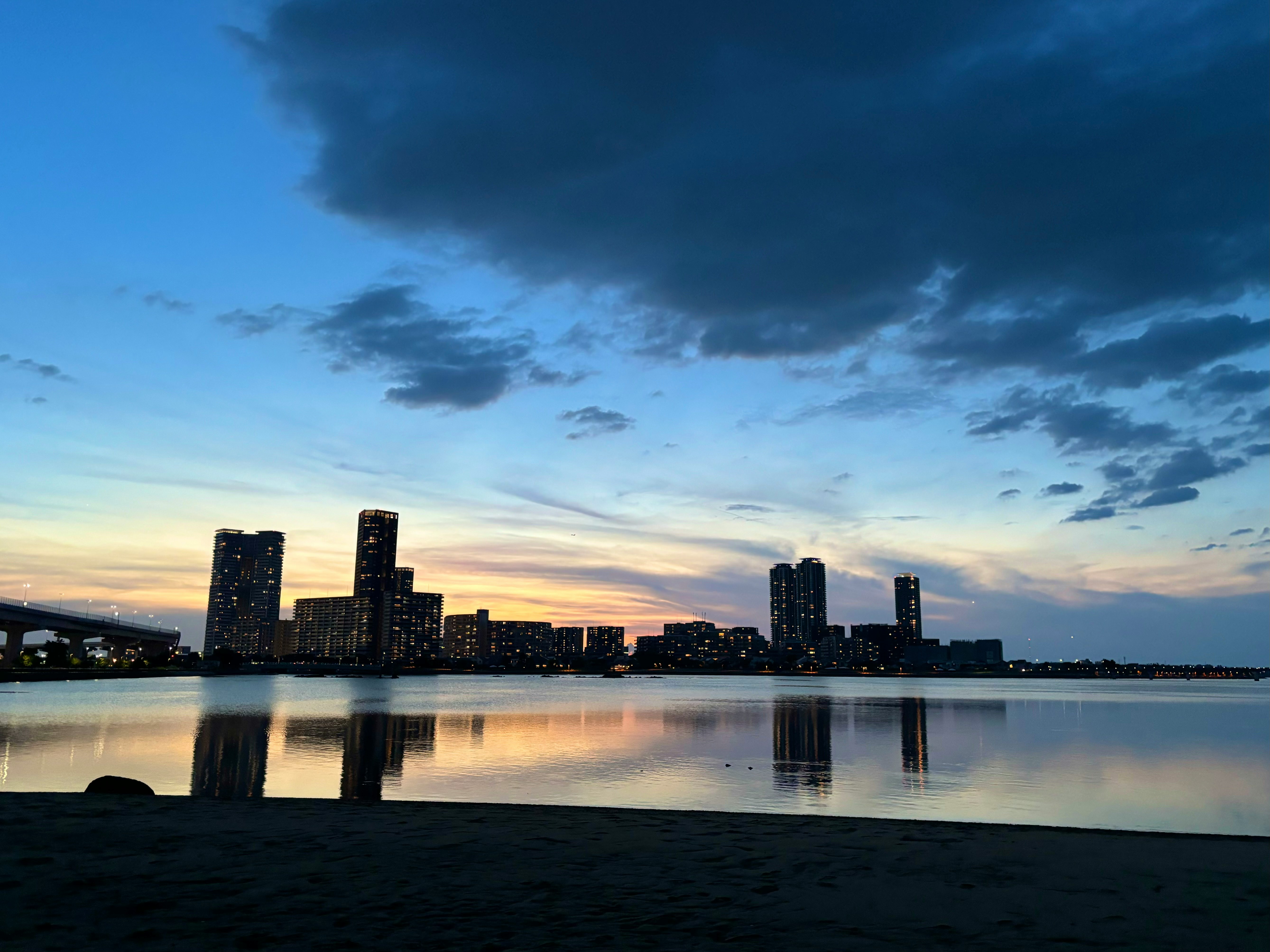 Skyline costiero al tramonto con riflessi sull’acqua