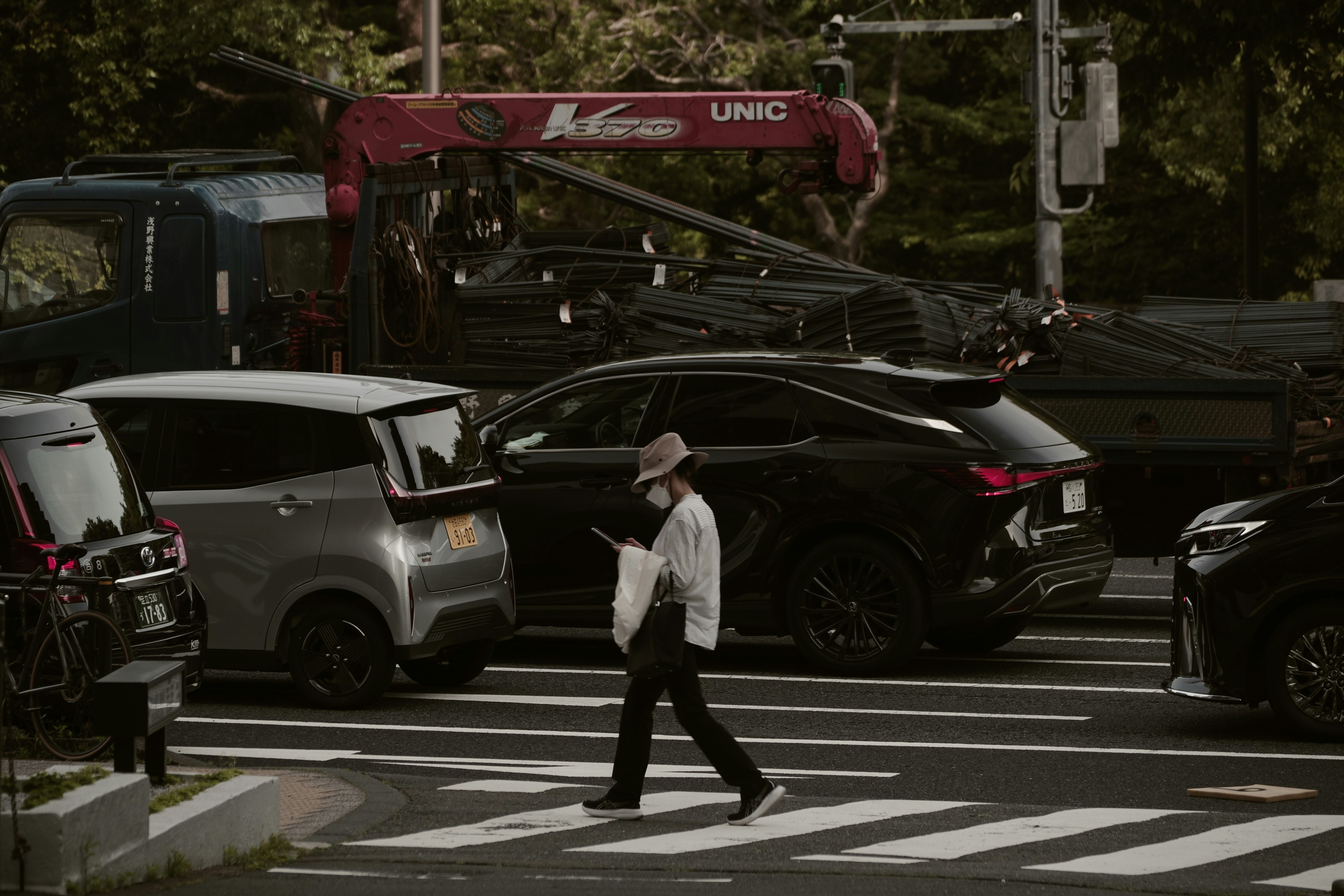 交差点を横切る歩行者と車のある東京の街並み