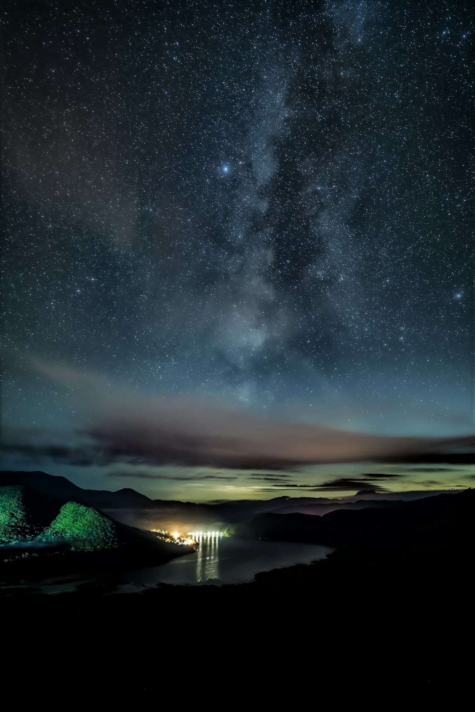 Stupendo paesaggio notturno con cielo stellato e Via Lattea riflessa sulla superficie del lago