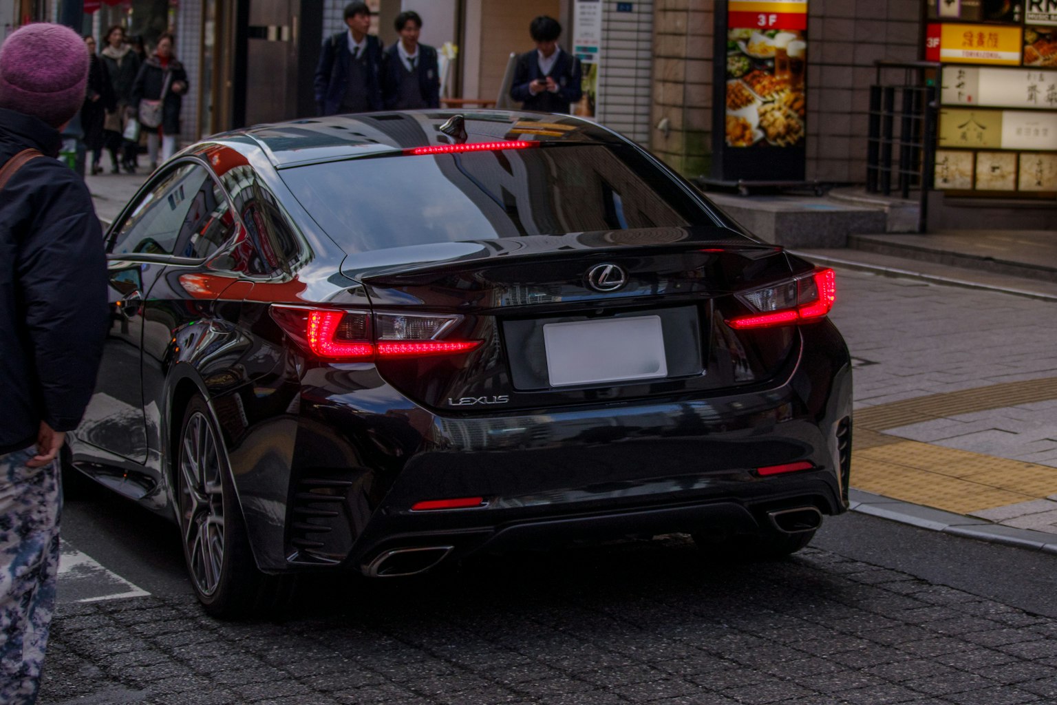 Vista trasera de un Lexus negro estacionado en una calle de la ciudad