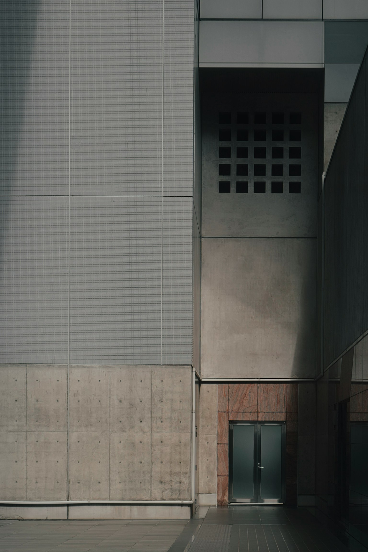 現代的な建物の一部であるコンクリートの壁とドアの画像