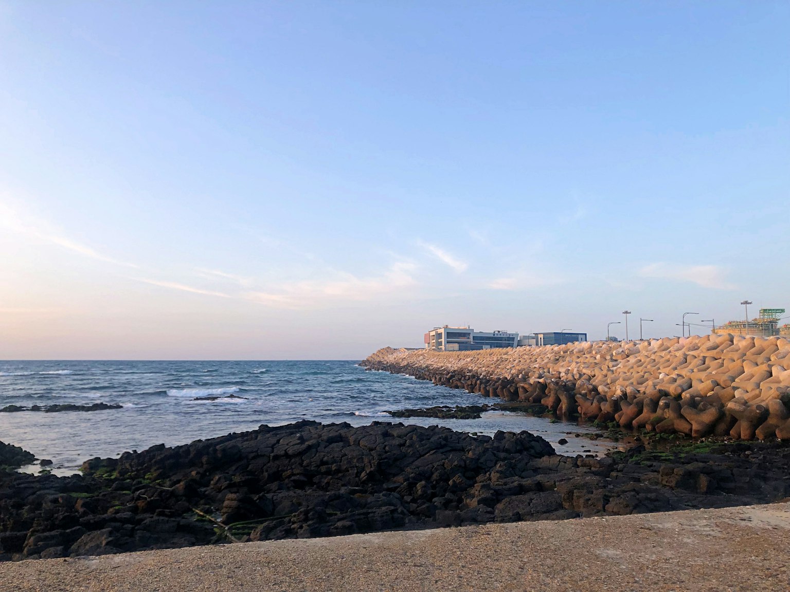 Küstenansicht mit Felsen und ruhigem Meer bei Sonnenuntergang