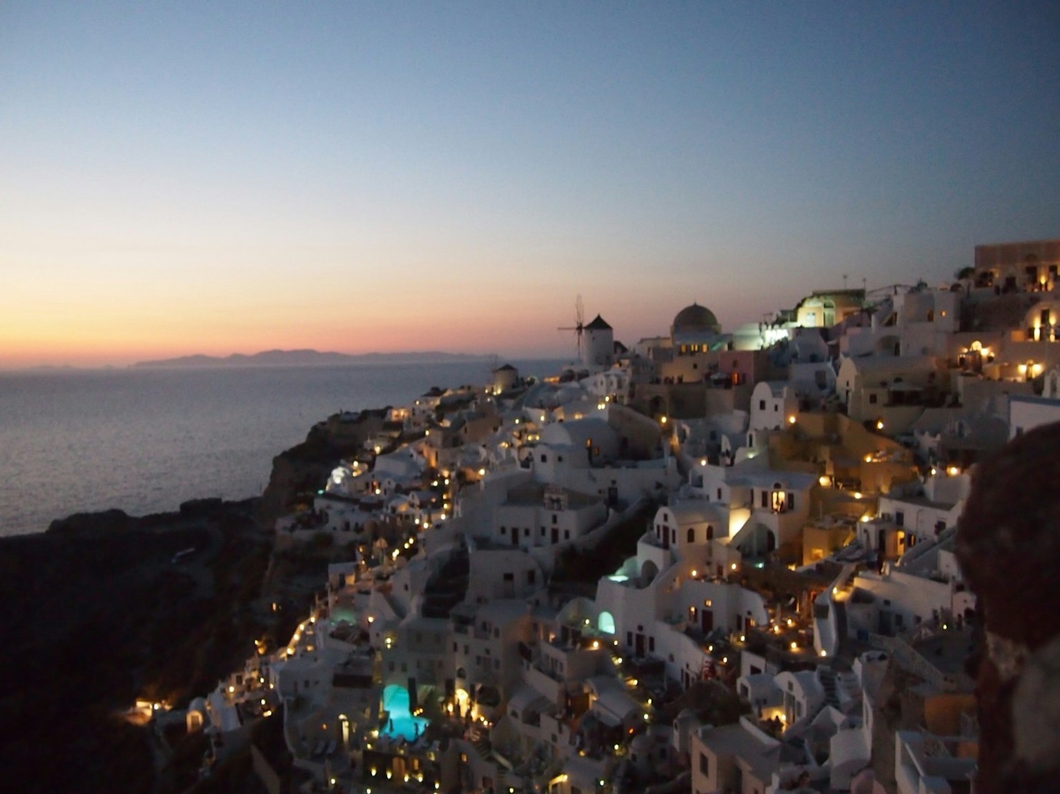 Santorin bei Nacht mit weißen Gebäuden und ruhigem Meer
