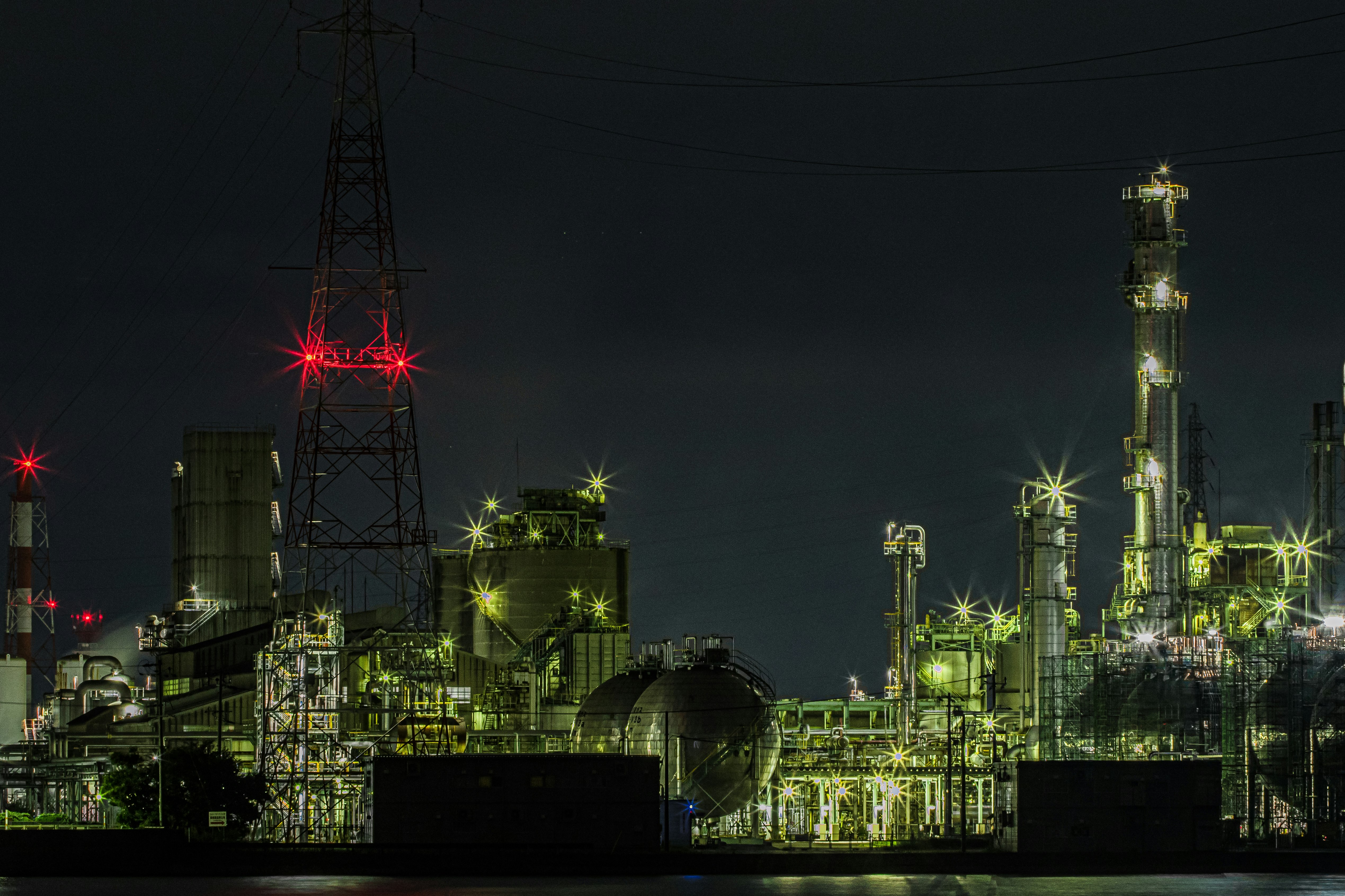 night-lit industrial plant with illuminated pipes and towers