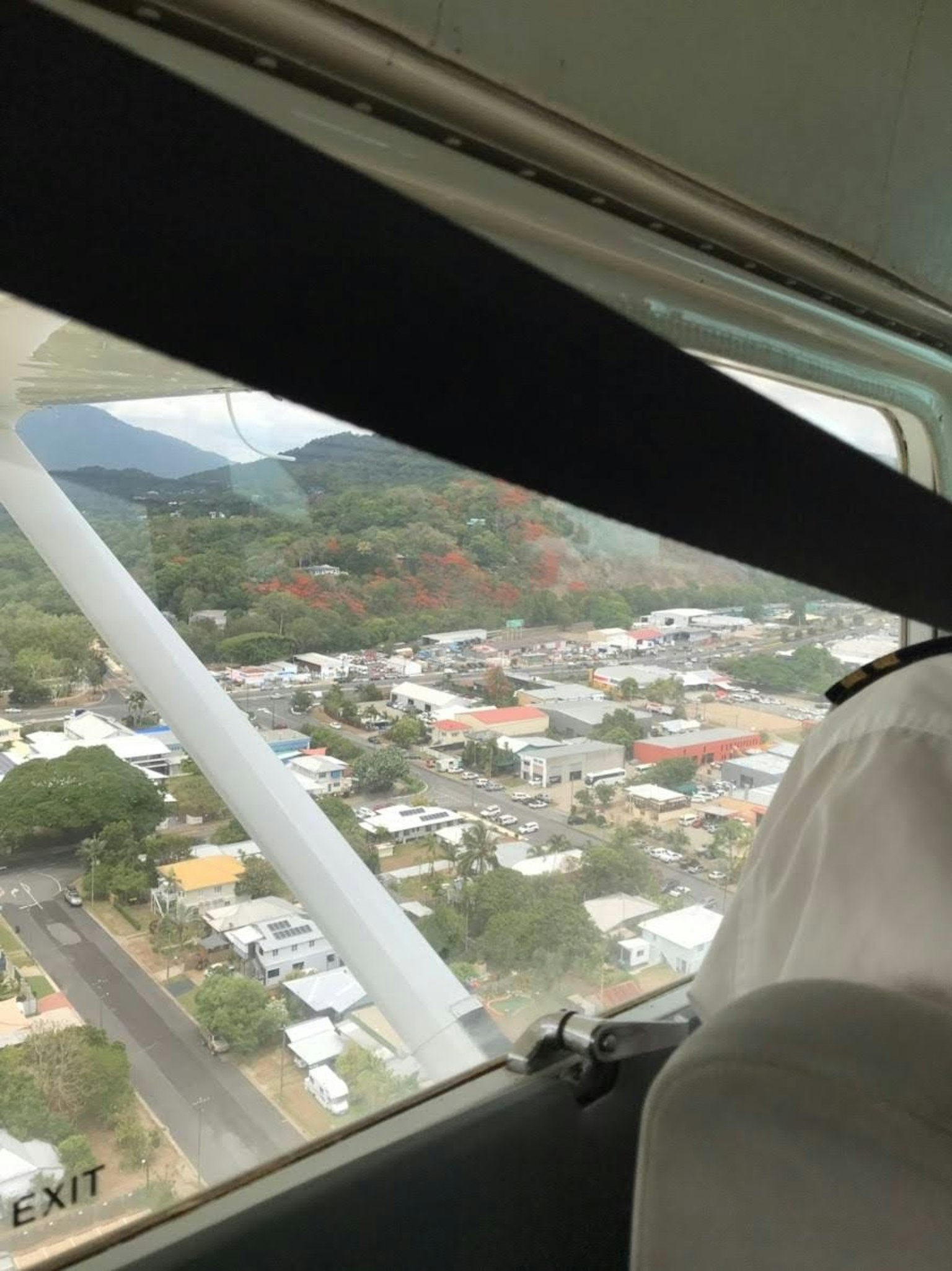 Vue depuis la fenêtre d'un avion montrant une ville et des montagnes