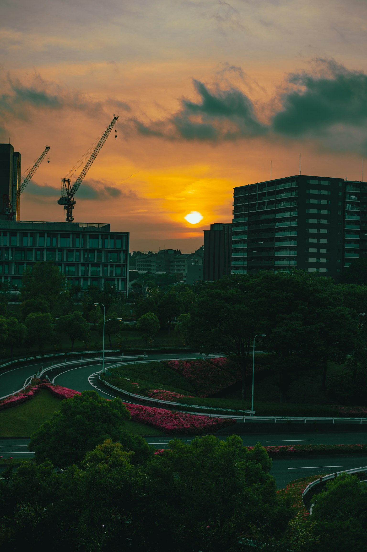 Stadtlandschaft bei Sonnenuntergang mit kurviger Straße und Gebäuden
