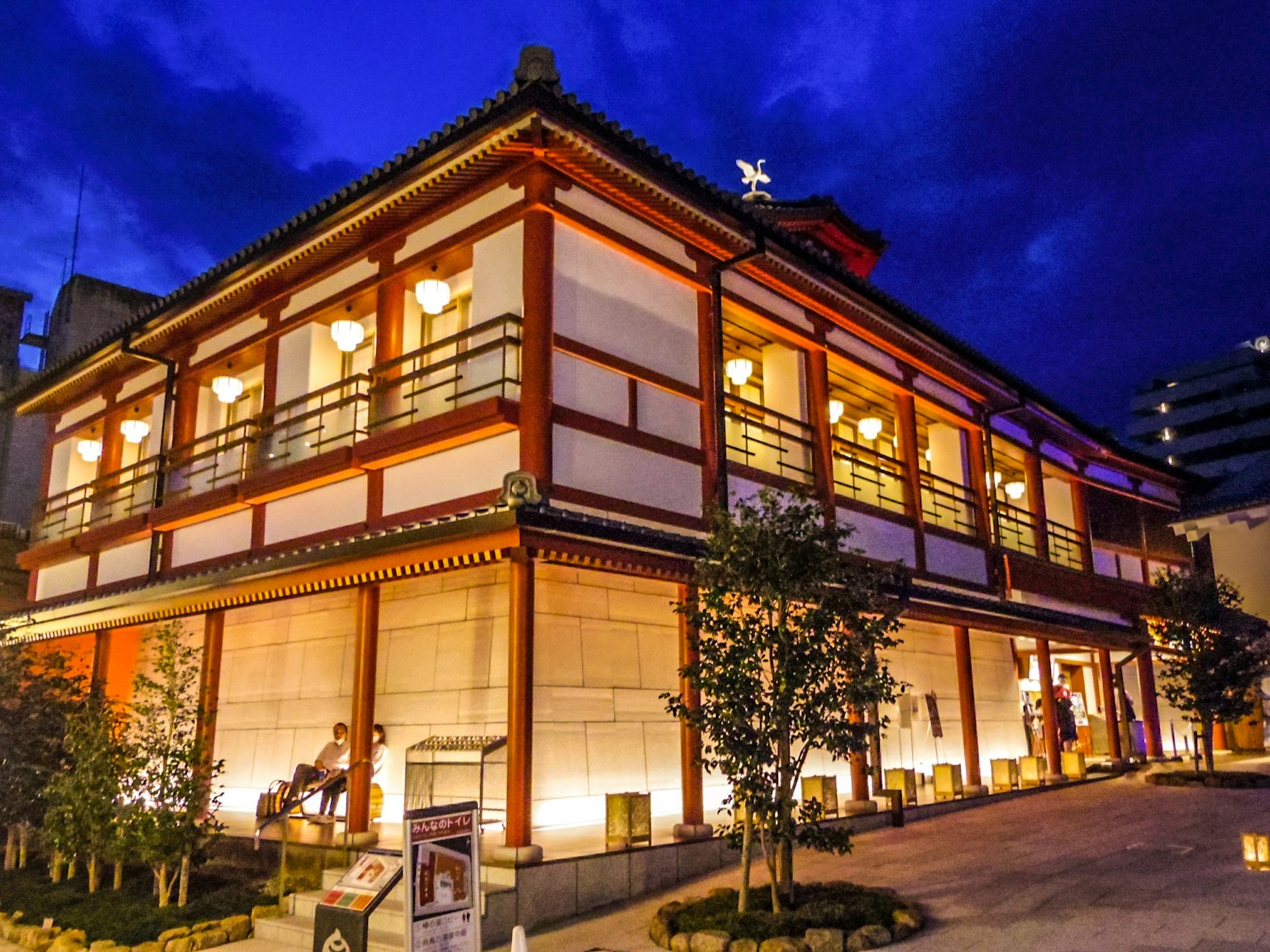 Bâtiment d'architecture japonaise traditionnelle illuminé la nuit sous un ciel sombre