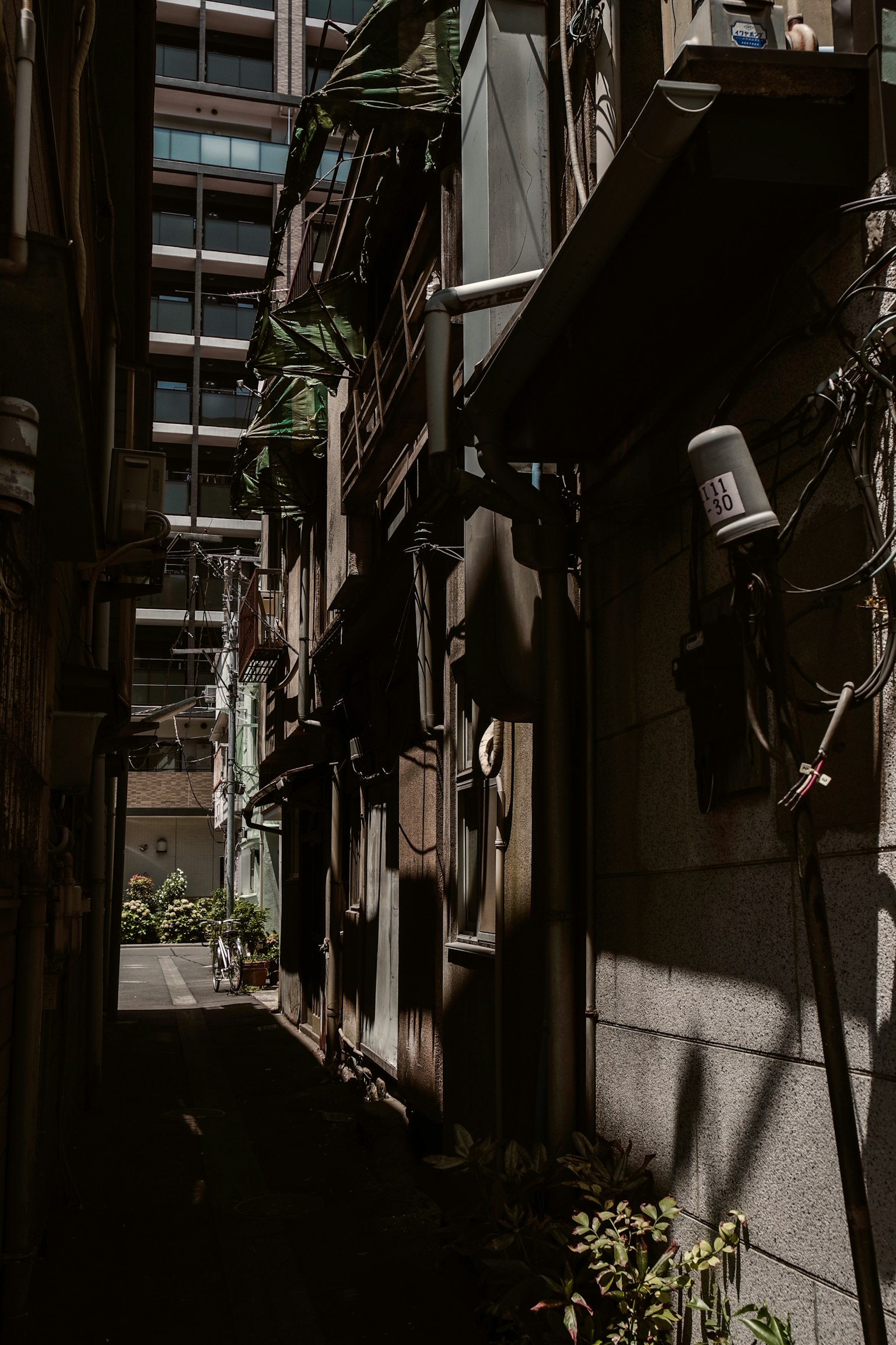 Vicolo stretto con edifici antichi accanto a grattacieli moderni