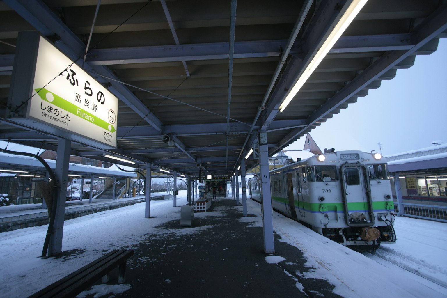 在雪地车站停靠的火车和方向标志