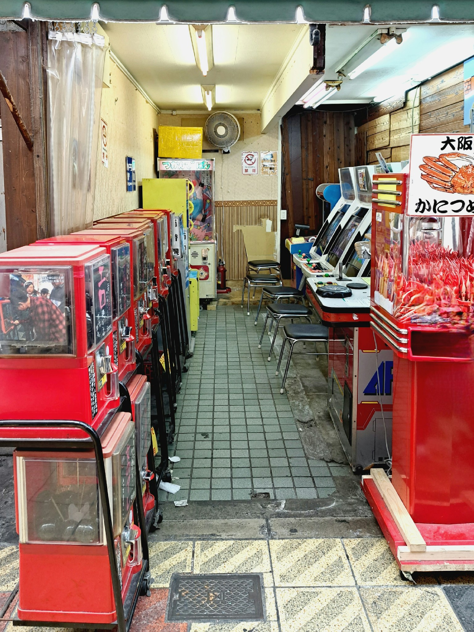 Sentiero stretto fiancheggiato da distributori automatici gashapon rossi