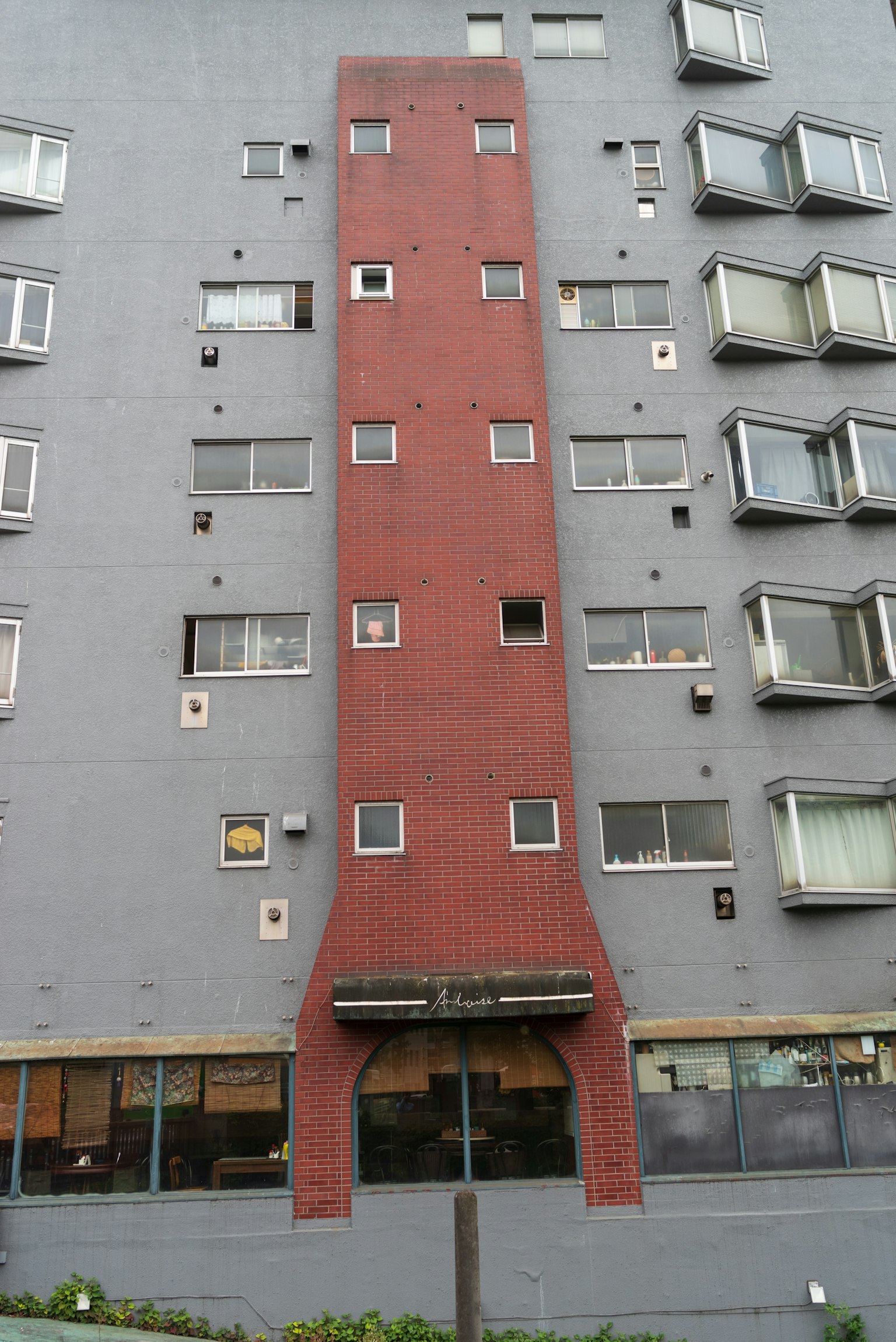 Edificio con facciata rossa stretta e struttura grigia vicina