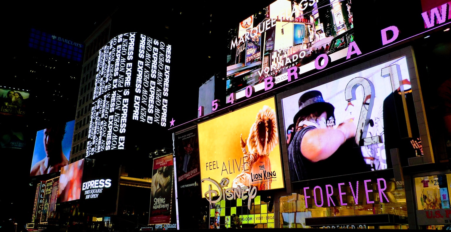 Pemandangan malam Times Square dengan tanda neon yang cerah dan iklan