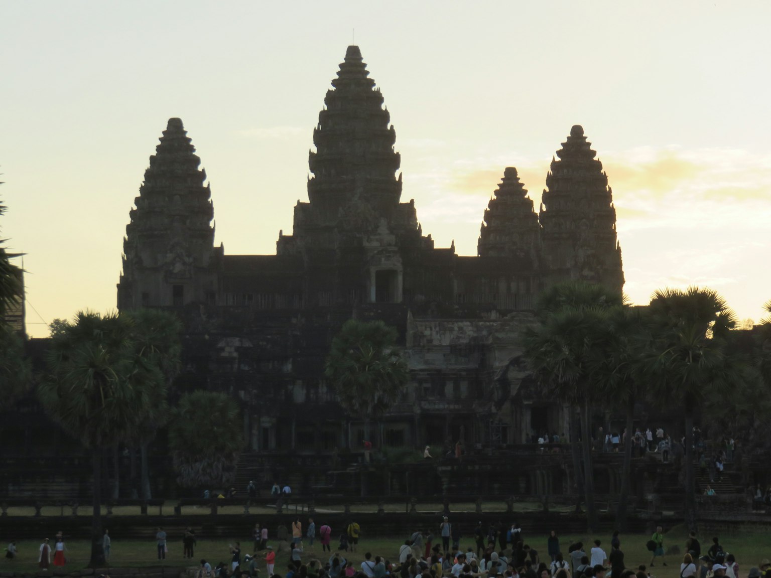 Silhouette di Angkor Wat al tramonto con turisti riuniti