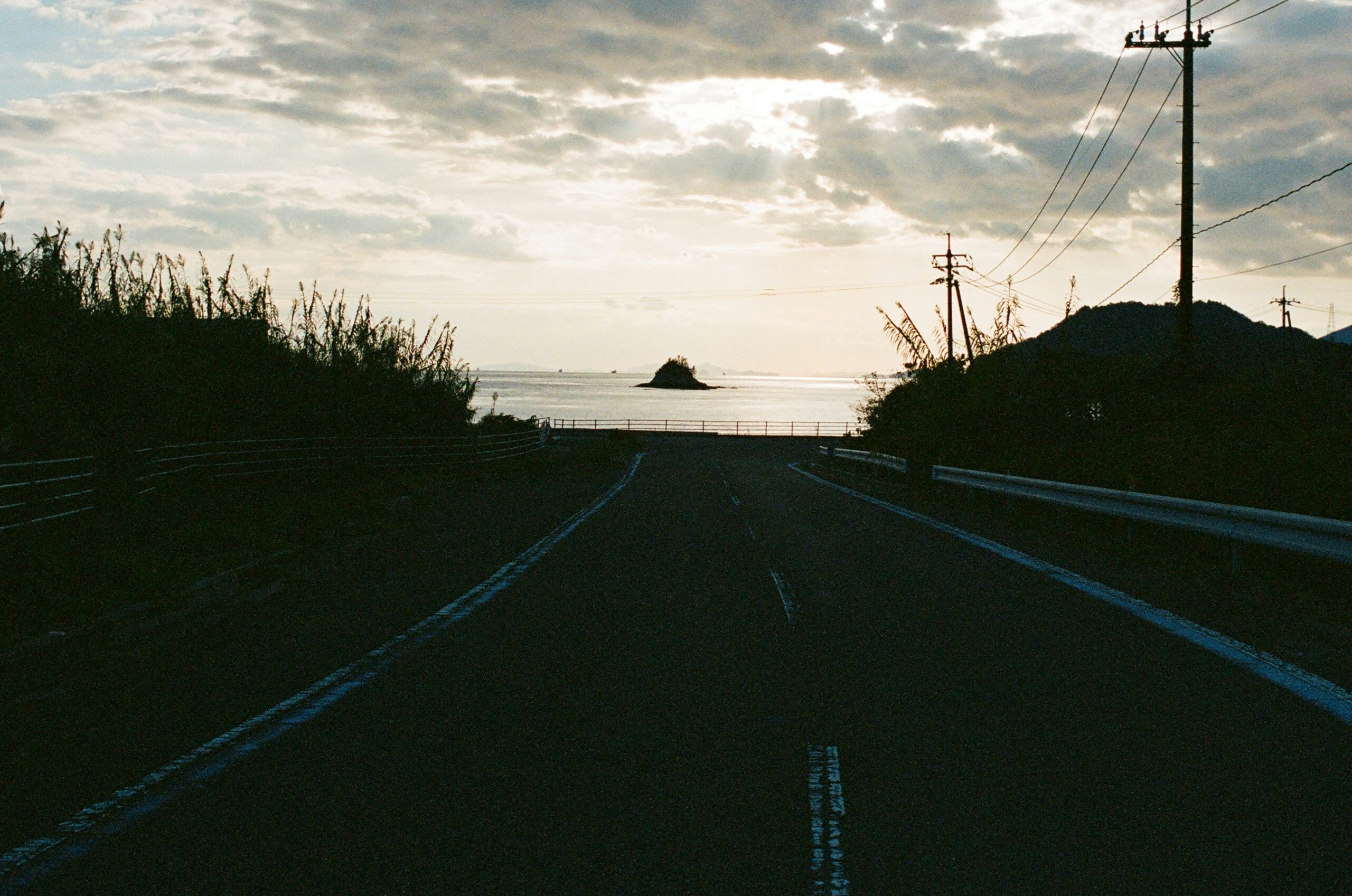 海沿いの道を走る夕暮れの風景