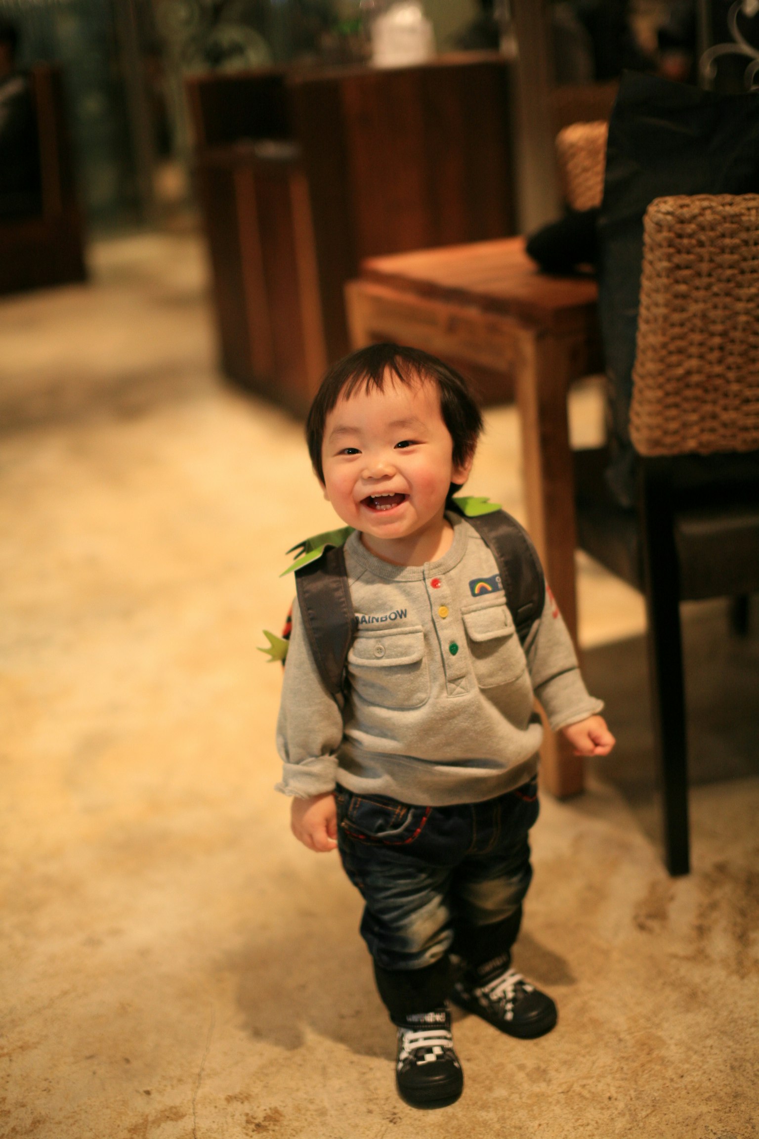 Niño sonriente con una mochila en un entorno interior