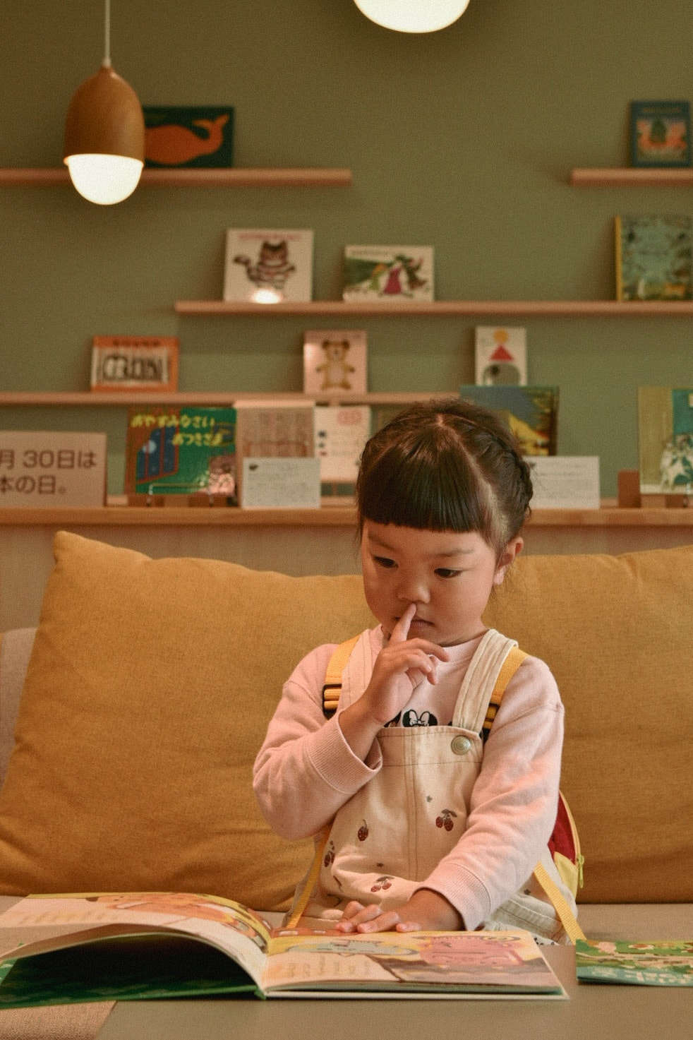 Indoor cafe-like space with a child reading a picture book