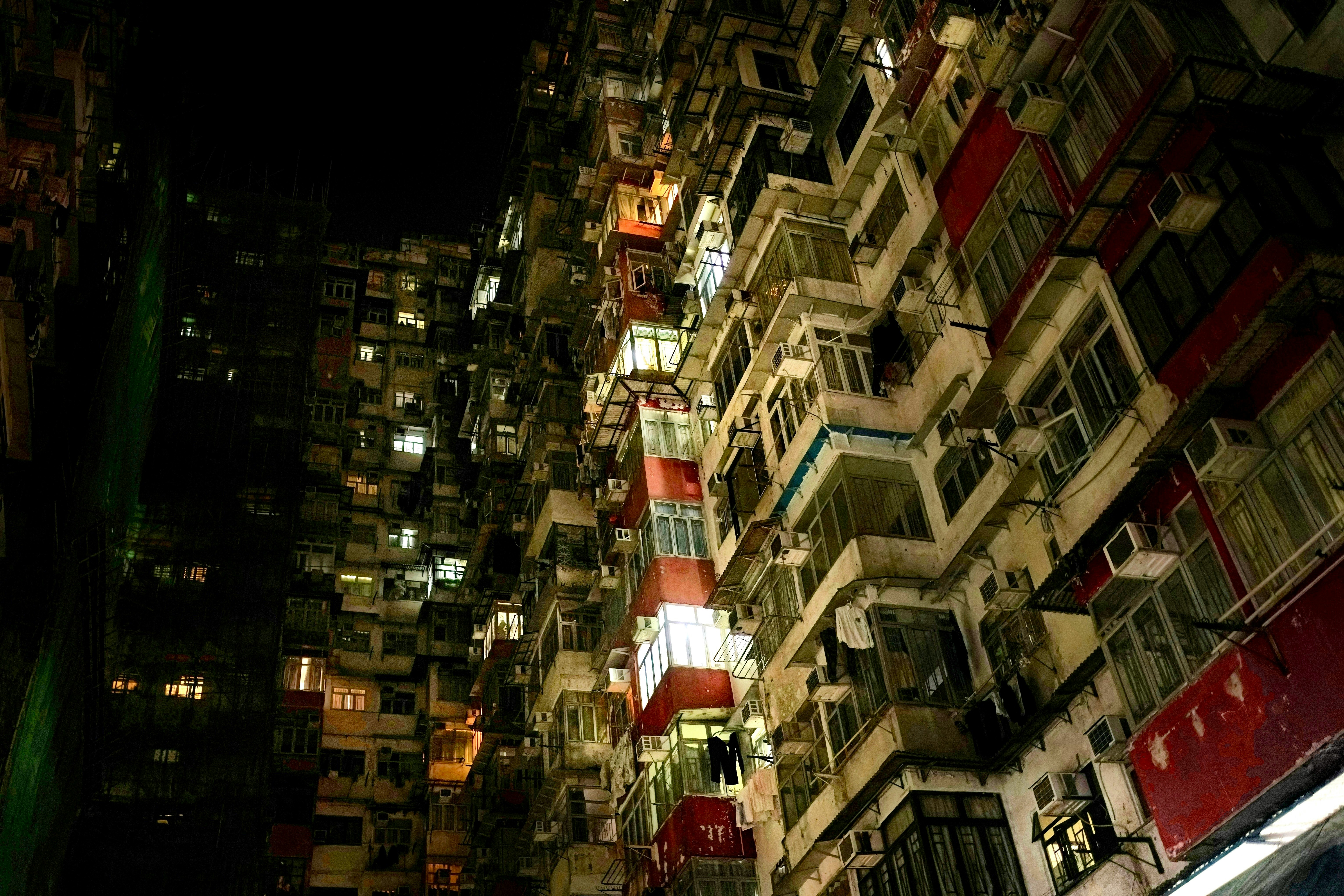 夜の高層住宅街に並ぶ窓とバルコニーの外観