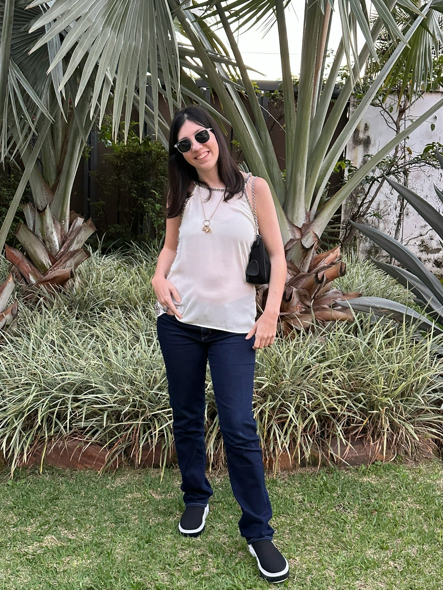 Frau steht in einem Garten mit Palmenpflanzen