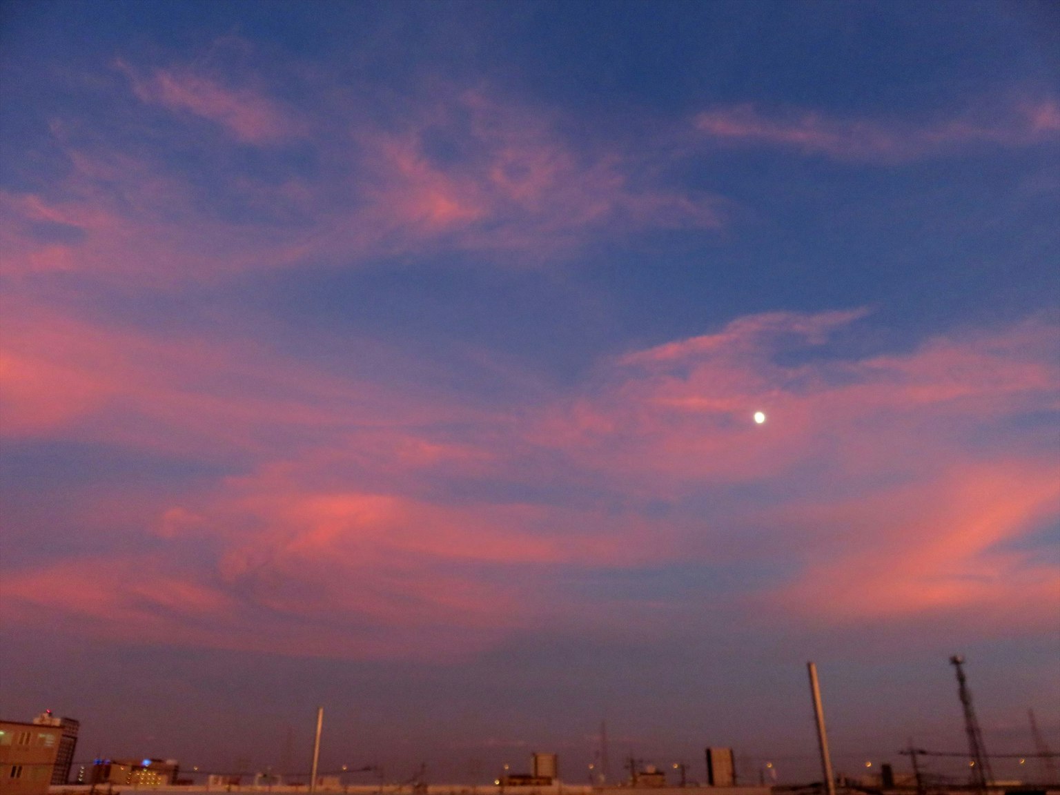 黃昏天空中的新月和柔和的粉紅色和藍色雲彩