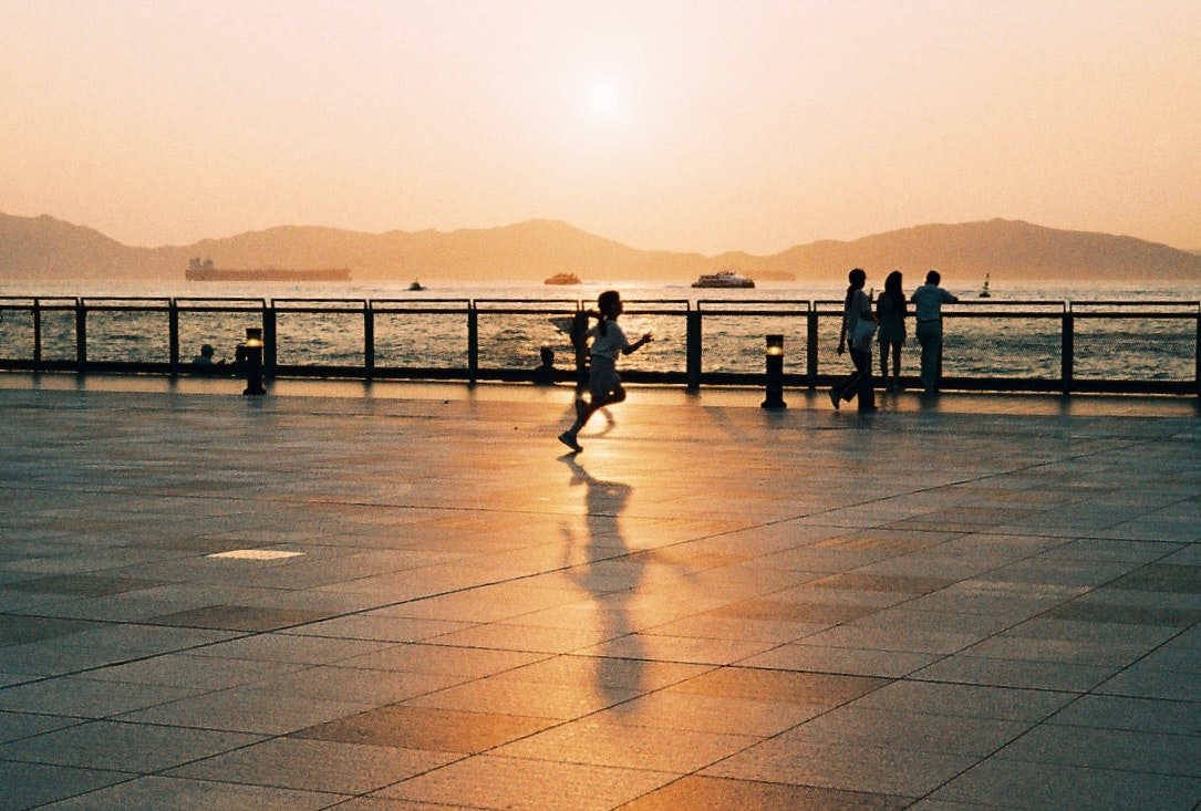 夕暮れの海辺を歩く人々のいる遊歩道